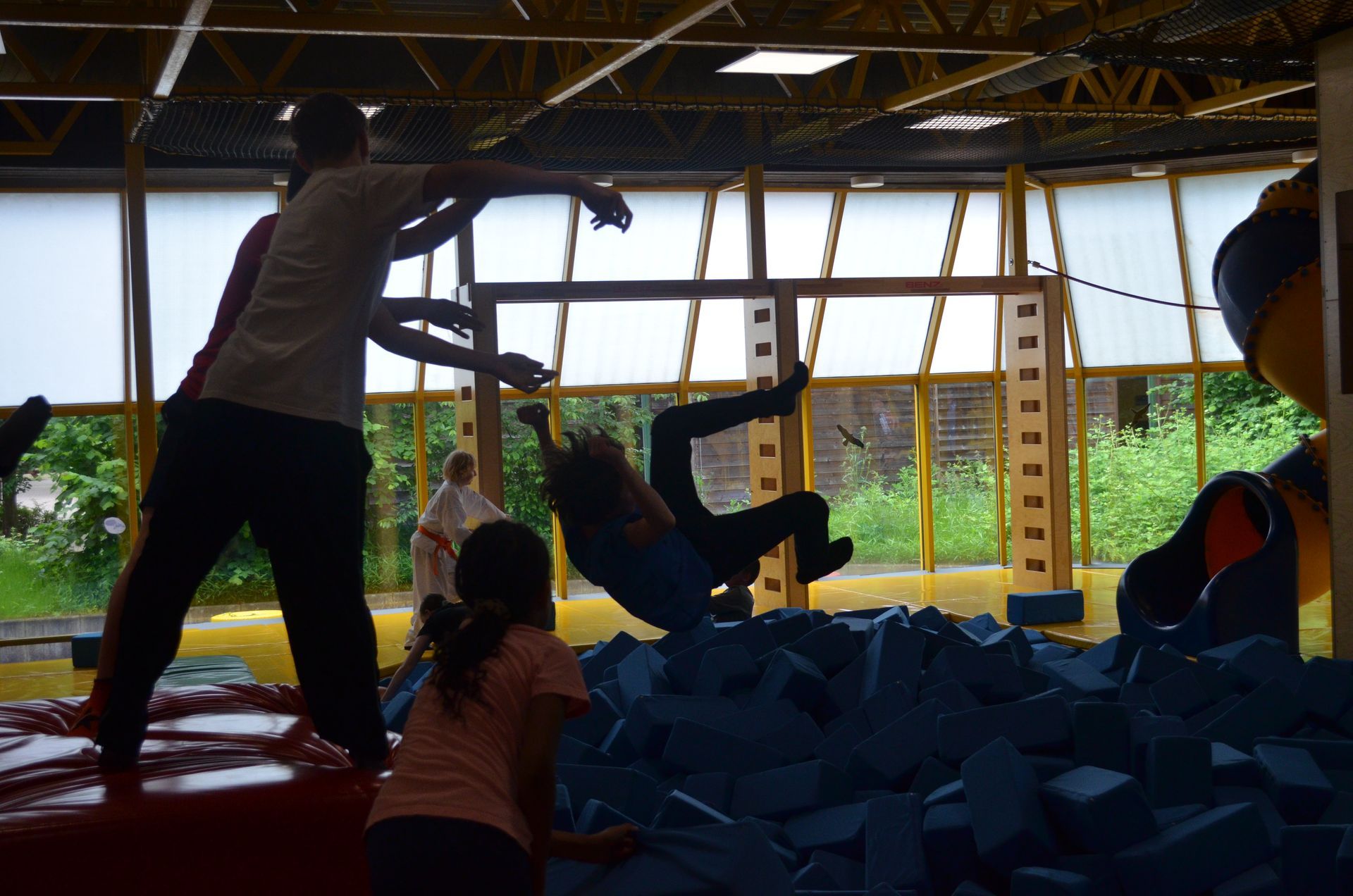 Eine Gruppe Kinder spielt in einem Trampolinpark - Karate-Jugendfreizeit.