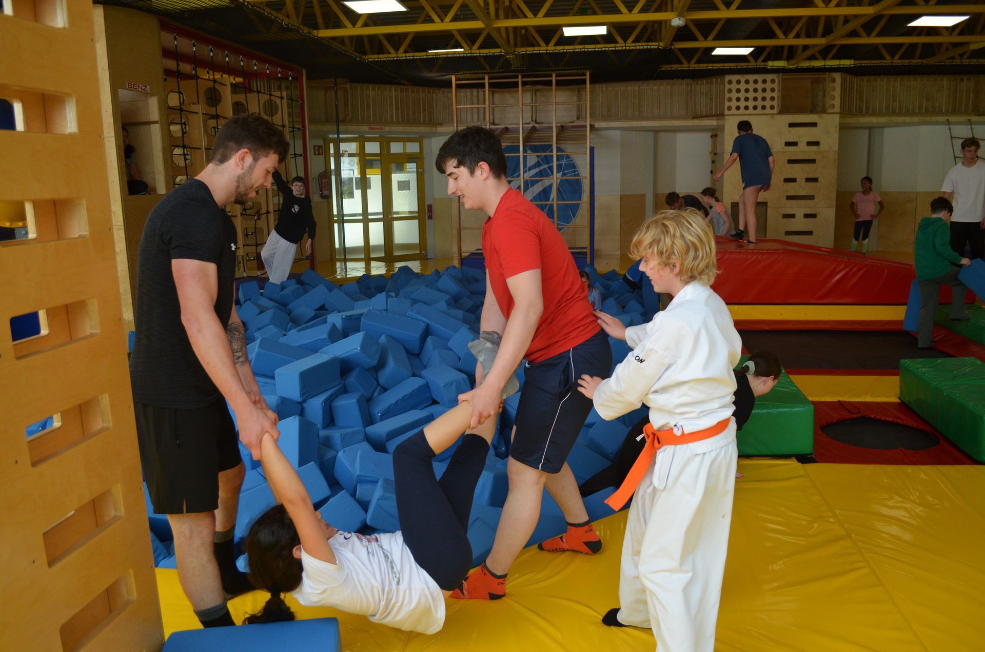 Eine Gruppe Leute spielt in einer Turnhalle mit Schaumstoffblöcken - Karate-Jugendfreizeit.