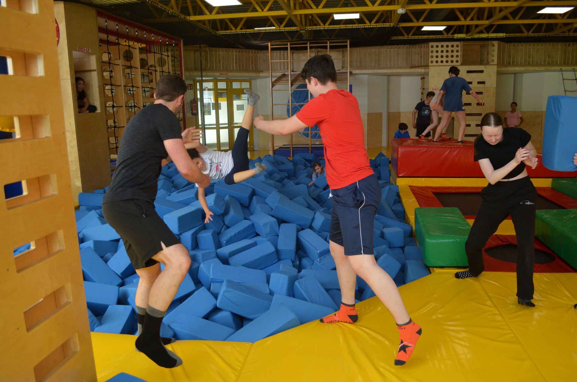Eine Gruppe Leute spielt in einer Turnhalle mit Schaumstoffblöcken - Karate-Jugendfreizeit.