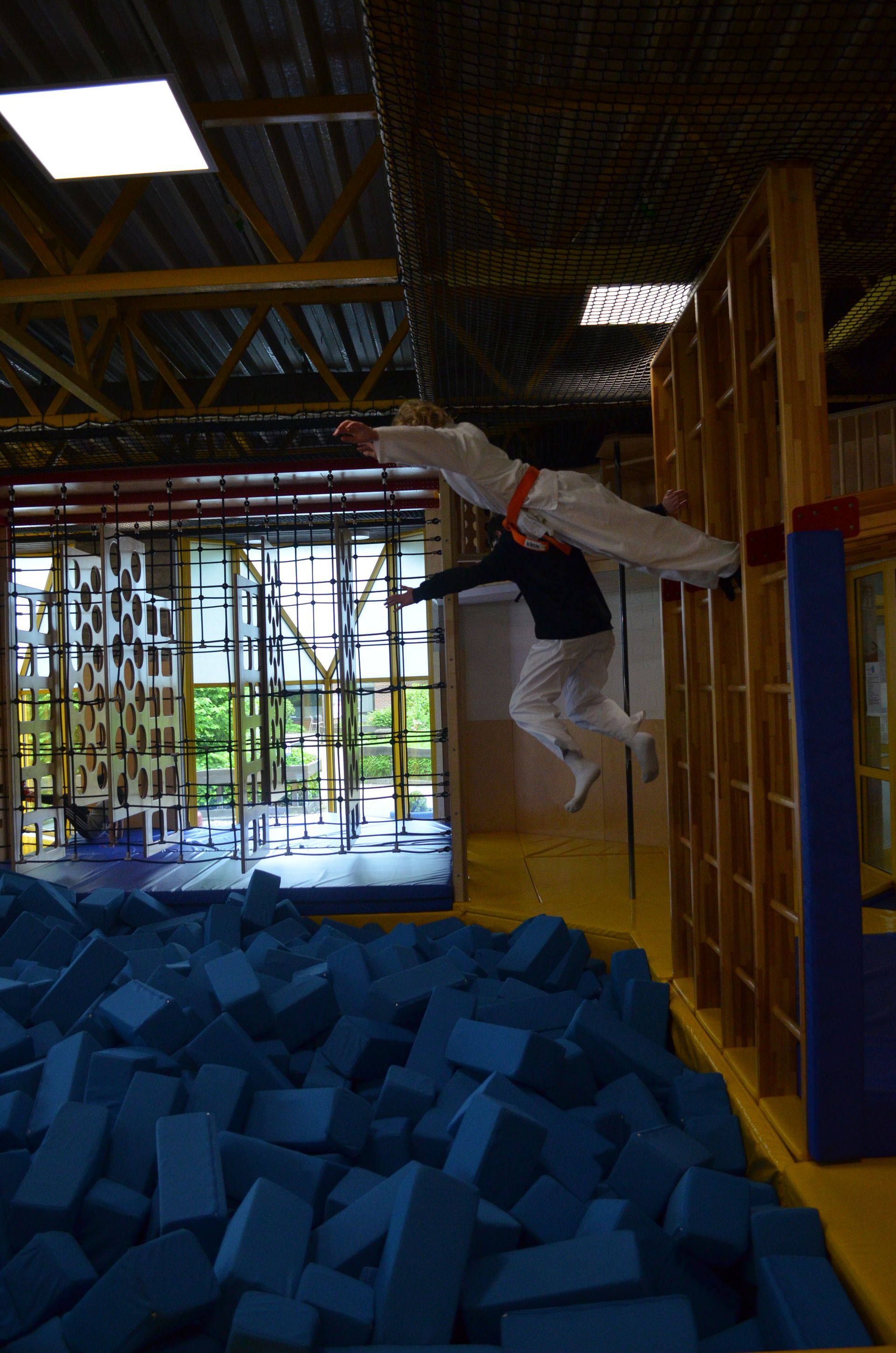 Eine Person springt über einen Stapel Schaumstoffblöcke - Karate-Jugendfreizeit.