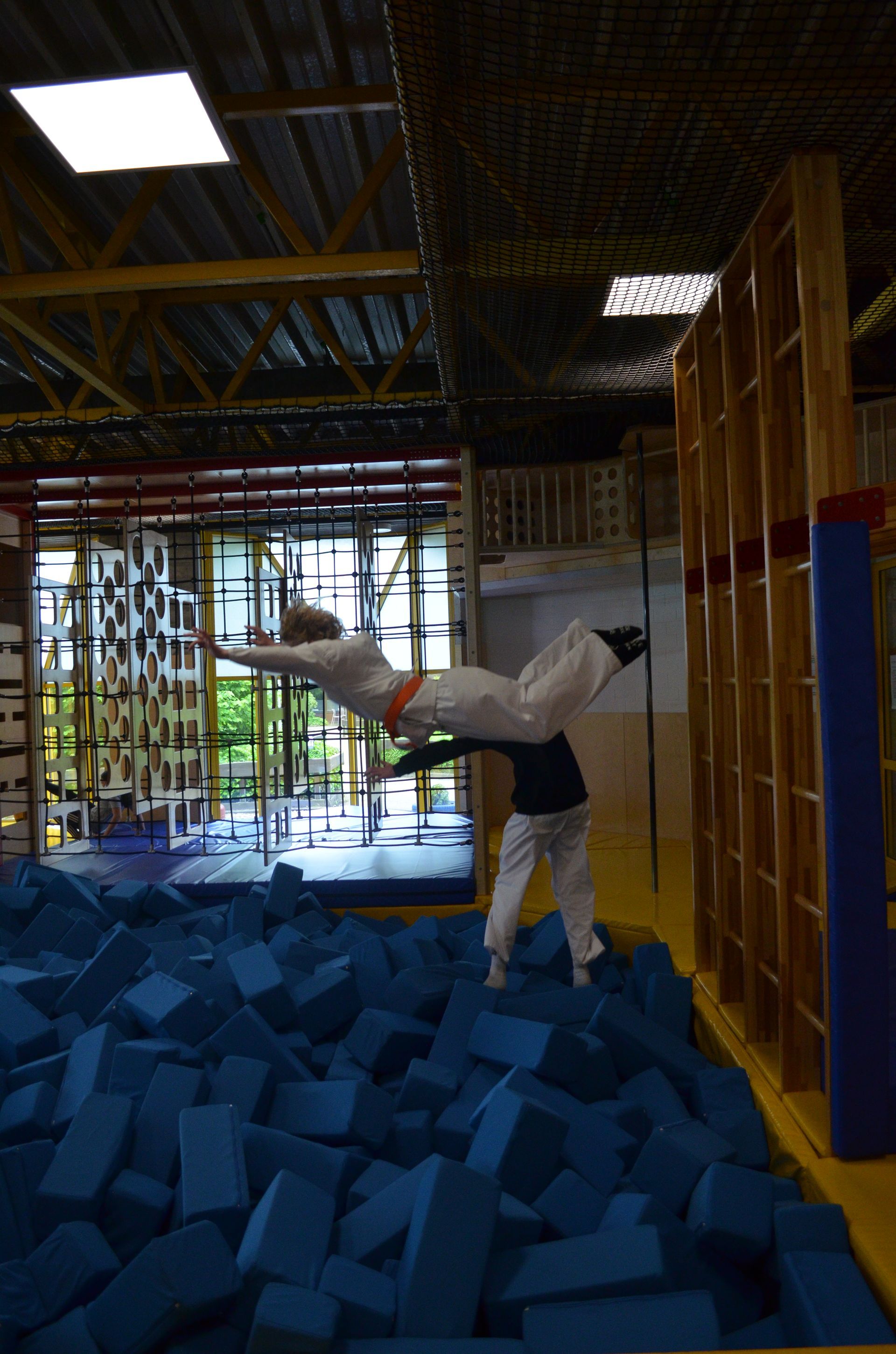 Eine Person macht in einem Fitnessstudio einen Trick auf einem Trampolin - Karate-Jugendfreizeit.