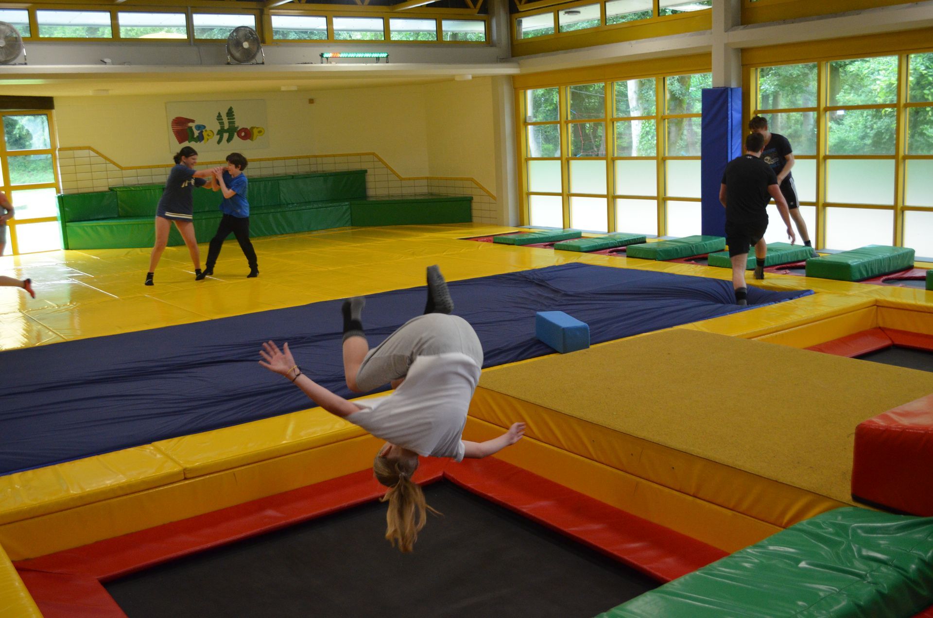 Eine Frau macht einen Handstand auf einem Trampolin in einem Fitnessstudio - Karate-Jugendfreizeit.