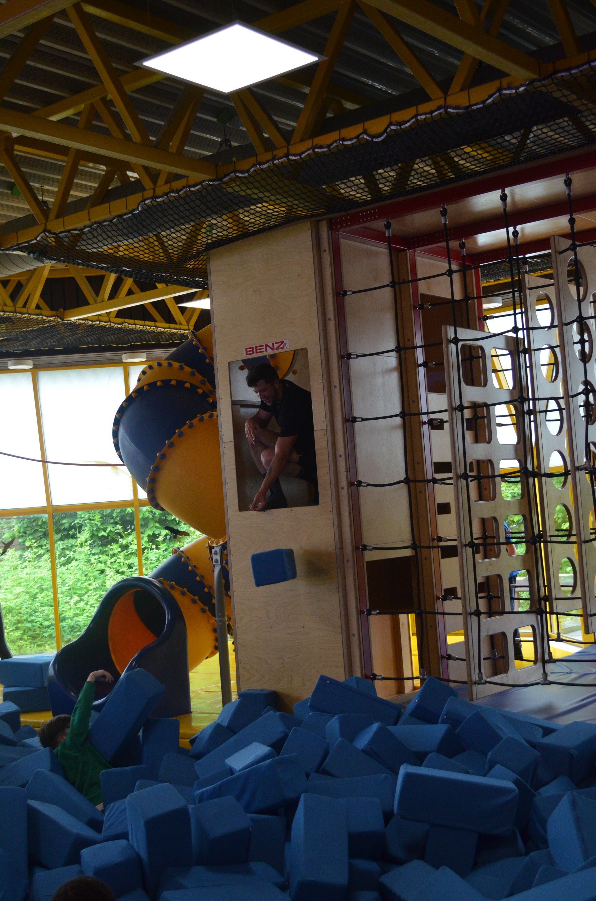 Ein Mann steht vor einer Rutsche auf einem Spielplatz - Karate-Jugendfreizeit.