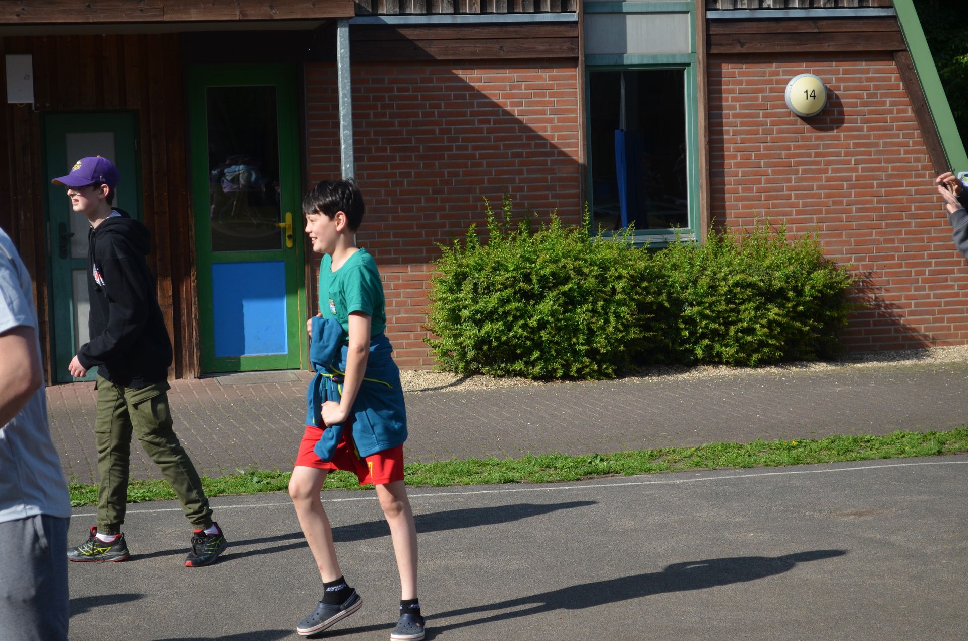 Eine Gruppe junger Jungen spielt Fußball vor einem Backsteingebäude 