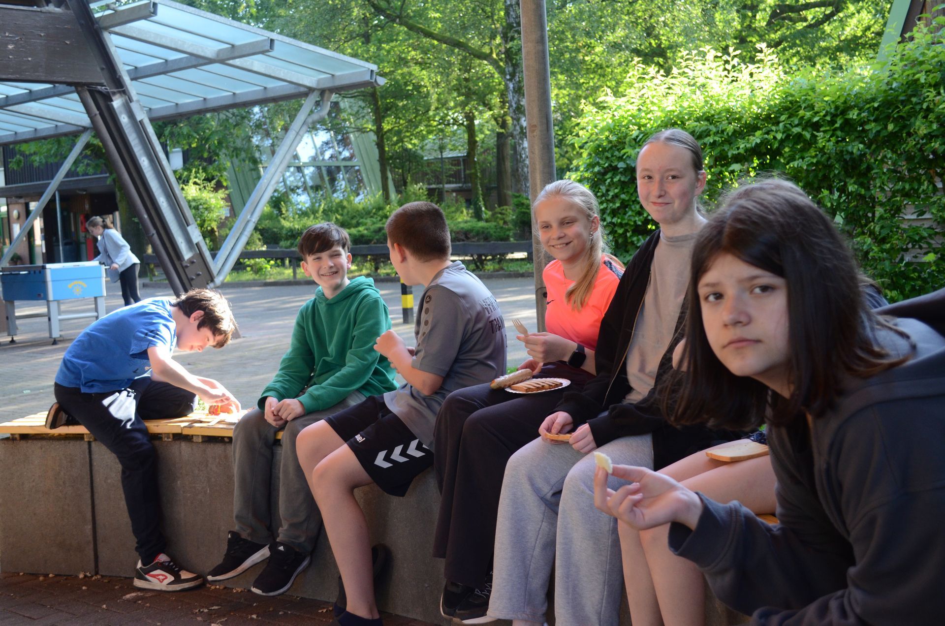 Eine Gruppe Kinder sitzt auf einer Bank und isst Eis - Karate-Jugendfreizeit.