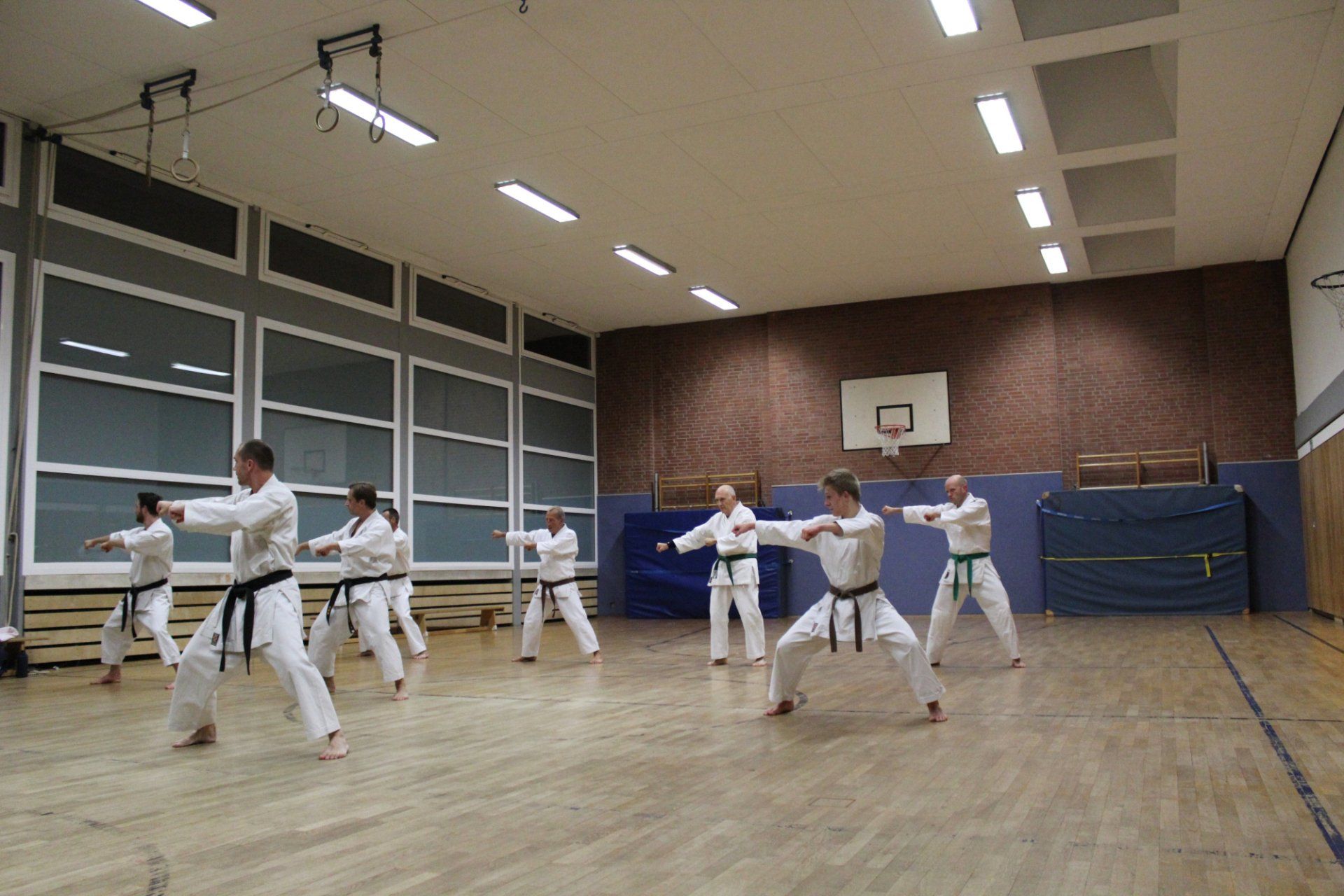 Eine Gruppe Leute trainiert in einem Fitnessstudio Karate.