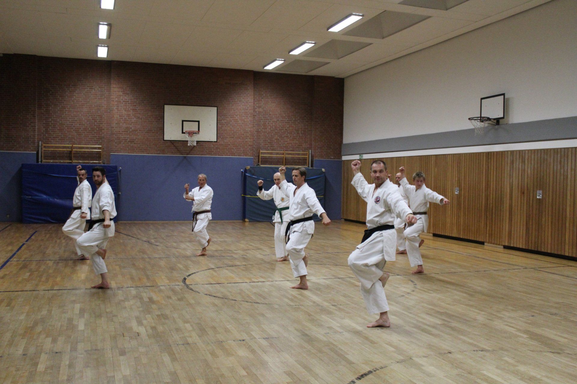 Eine Gruppe Leute trainiert in einem Fitnessstudio Karate.