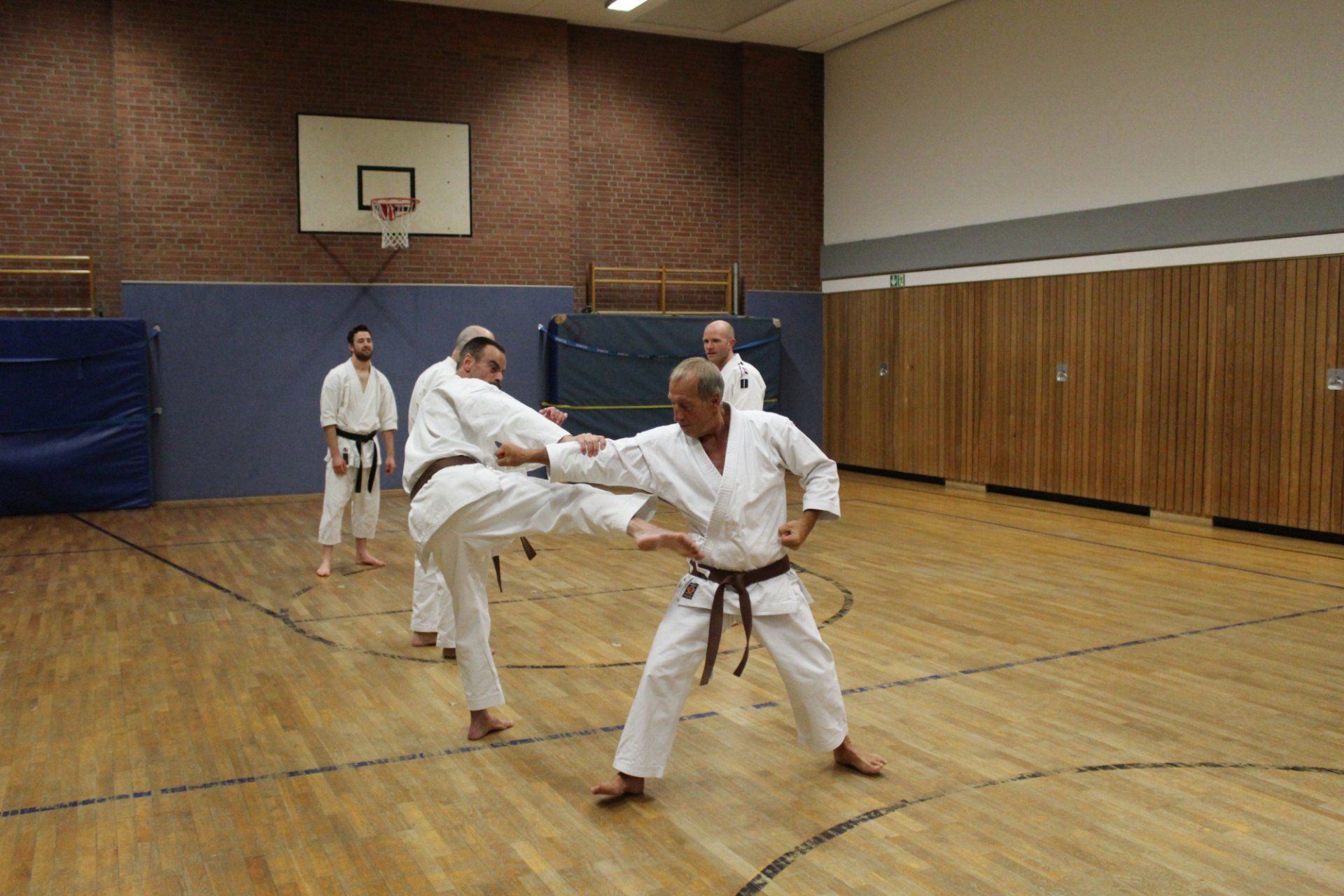 Eine Gruppe Männer trainiert in einem Fitnessstudio Karate.