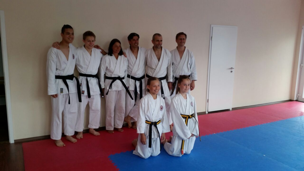 Eine Gruppe von Menschen in Karateuniformen posiert in einem Fitnessstudio für ein Foto.
