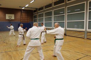 Eine Gruppe Männer trainiert in einem Fitnessstudio Karate.