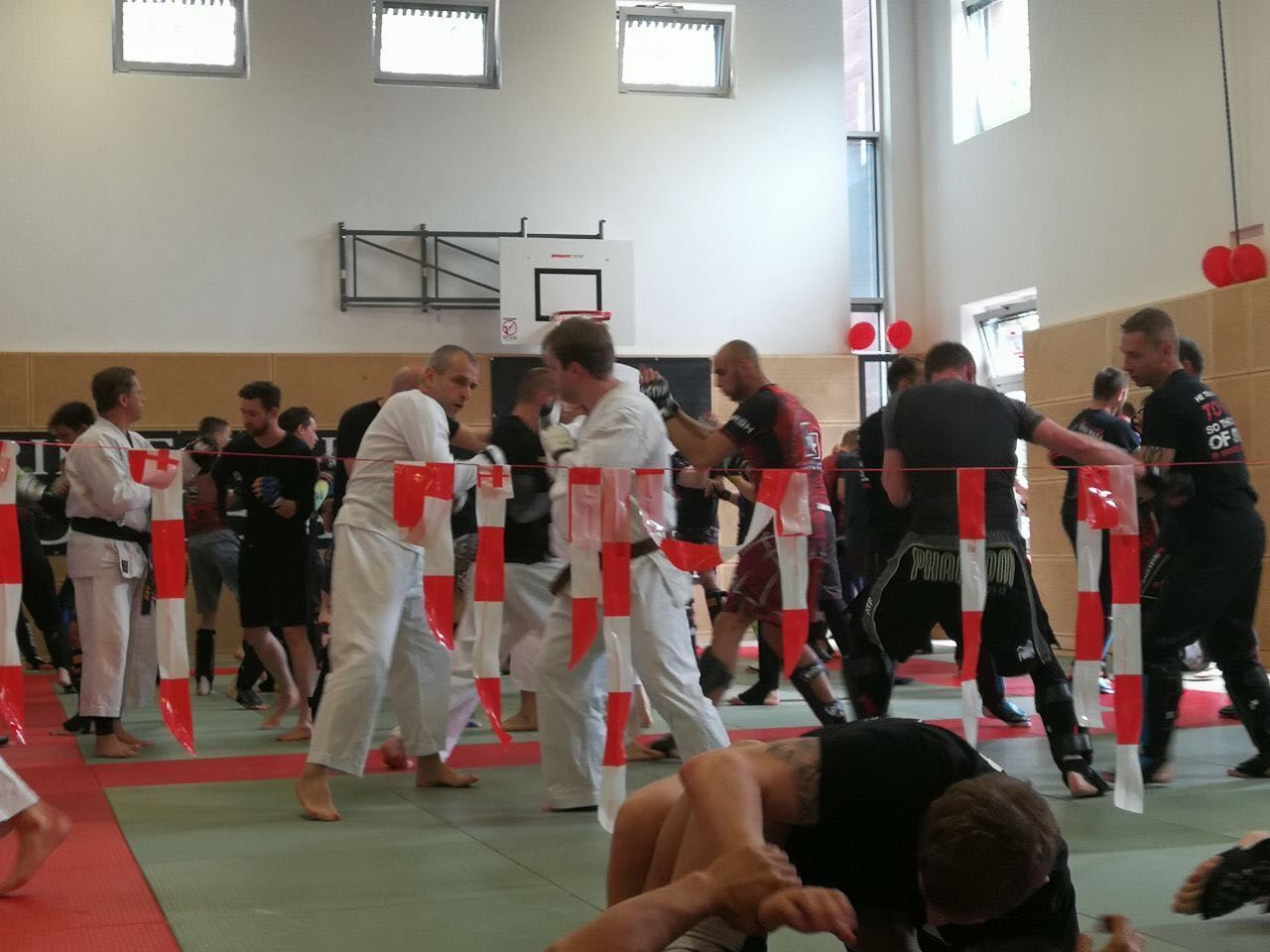 Eine Gruppe von Menschen praktiziert Kampfsport in einem Fitnessstudio