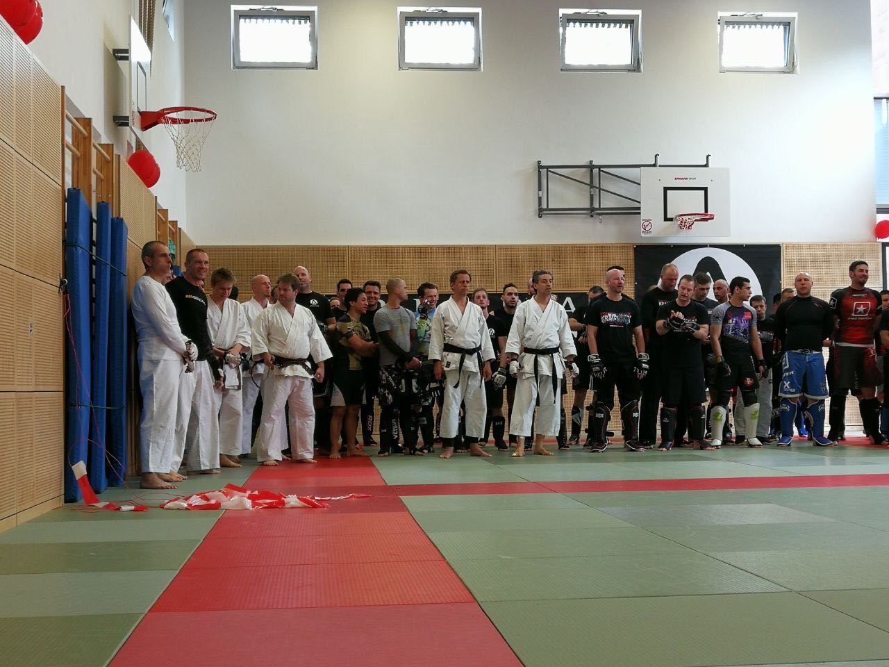 Eine Gruppe von Menschen in Karateuniformen steht in einem Fitnessstudio
