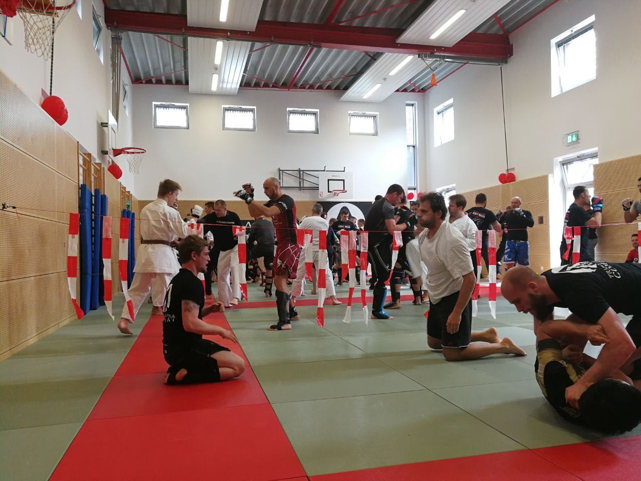 Eine Gruppe von Leuten trainiert in einem Fitnessstudio Kampfsport.