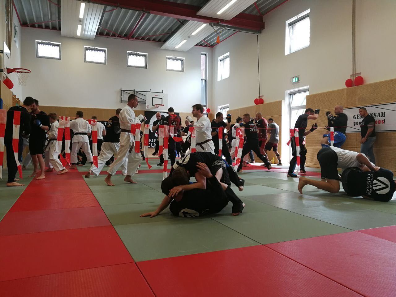 Eine Gruppe von Leuten trainiert in einem Fitnessstudio Kampfsport.