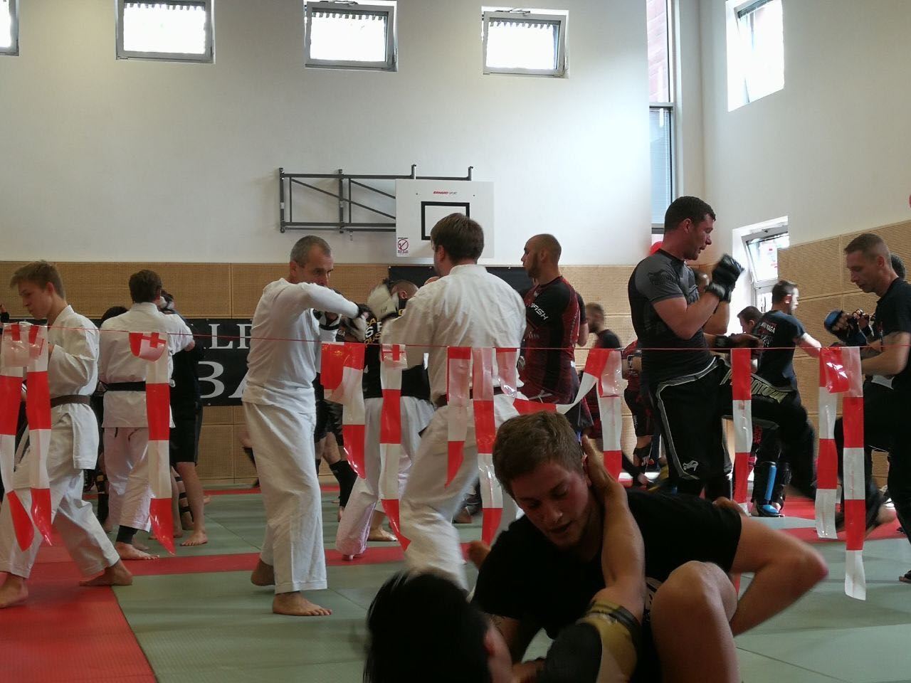 Eine Gruppe von Menschen praktiziert Kampfsport in einem Fitnessstudio mit der Nummer 3 an der Wand