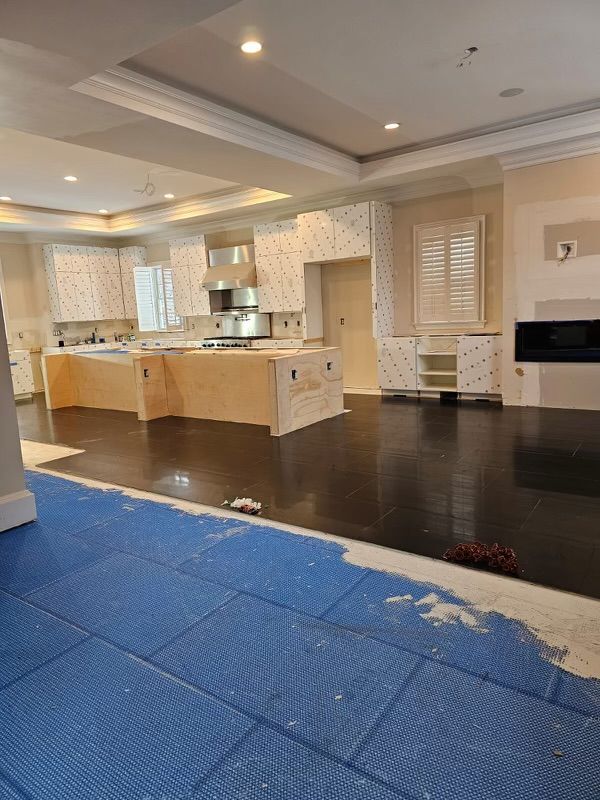 A large empty kitchen with a blue mat on the floor.