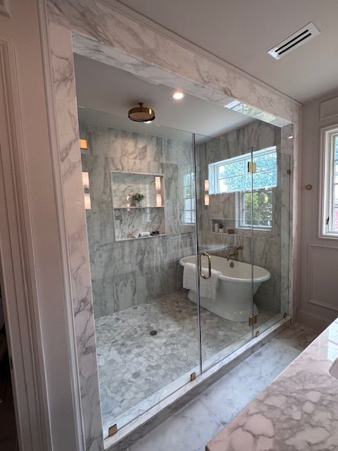 A bathroom with a bathtub , sink , mirror and shower.