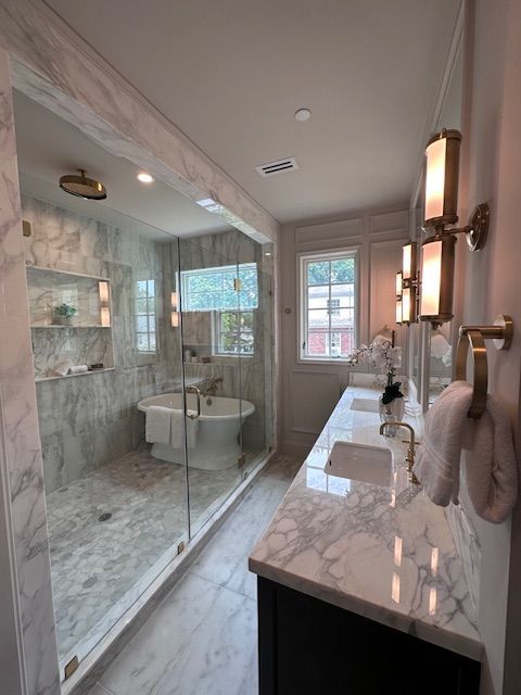 A bathroom with a tub , sink , and shower.