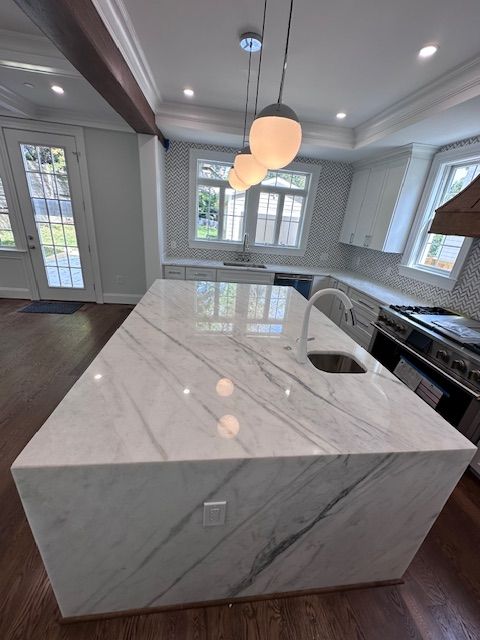 A kitchen with a large island and a sink.