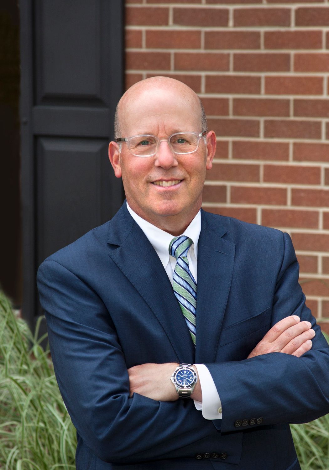 A man and a woman are sitting on a dock overlooking a lake.