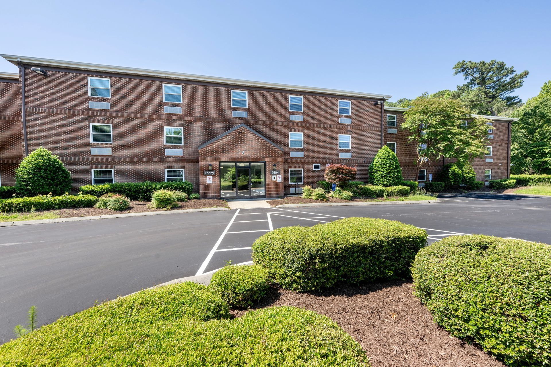 A large brick building with a parking lot in front of it