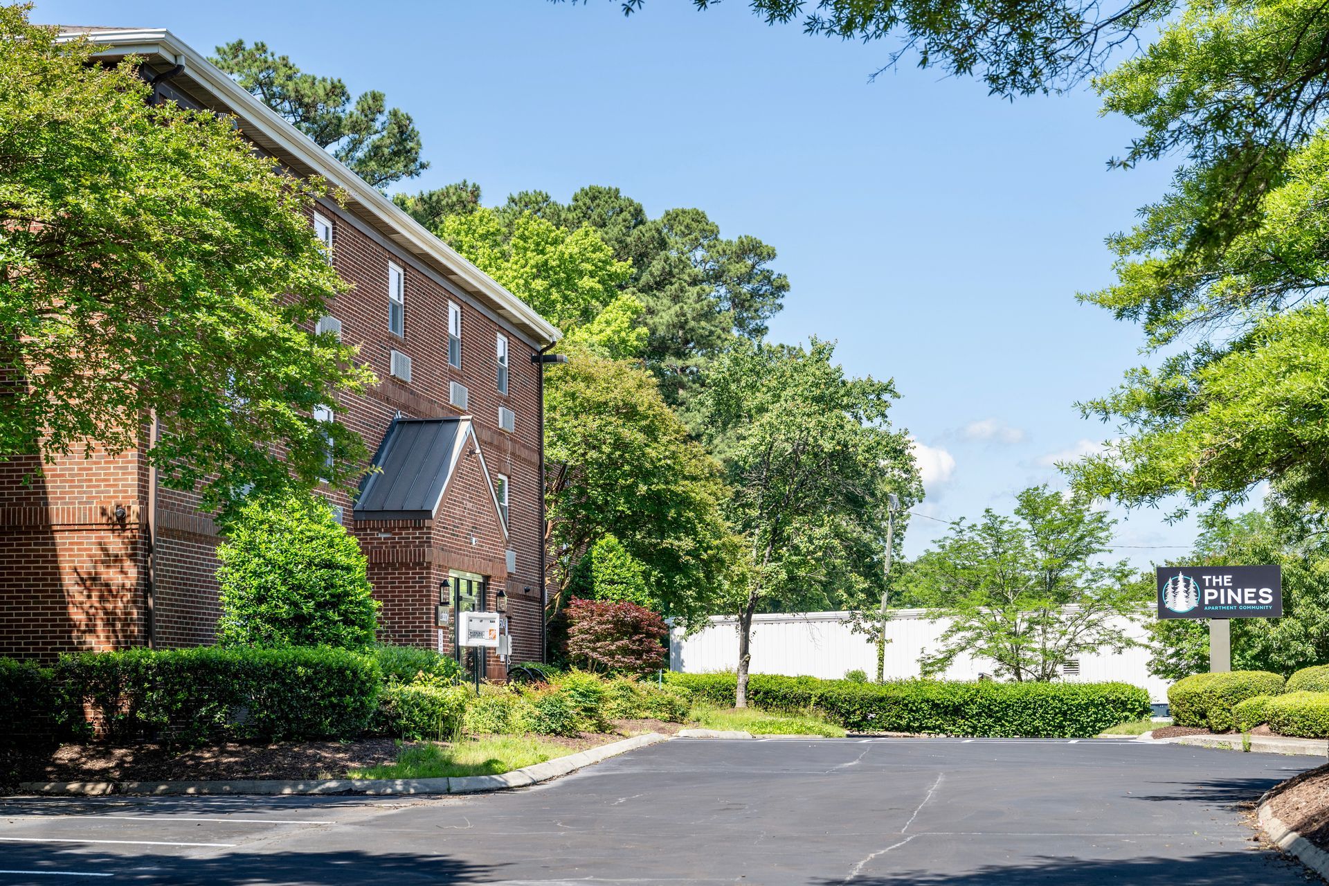 A large brick building with a parking lot in front of it.