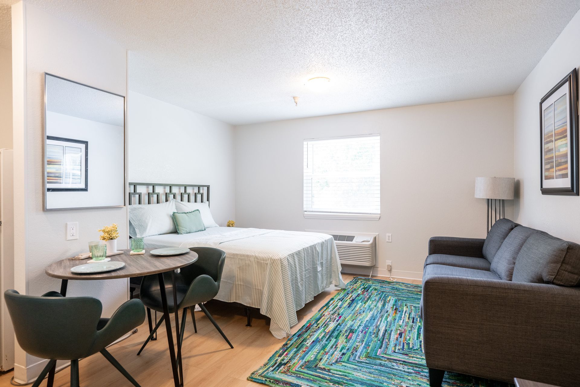 A bedroom with a bed , couch , table and chairs.