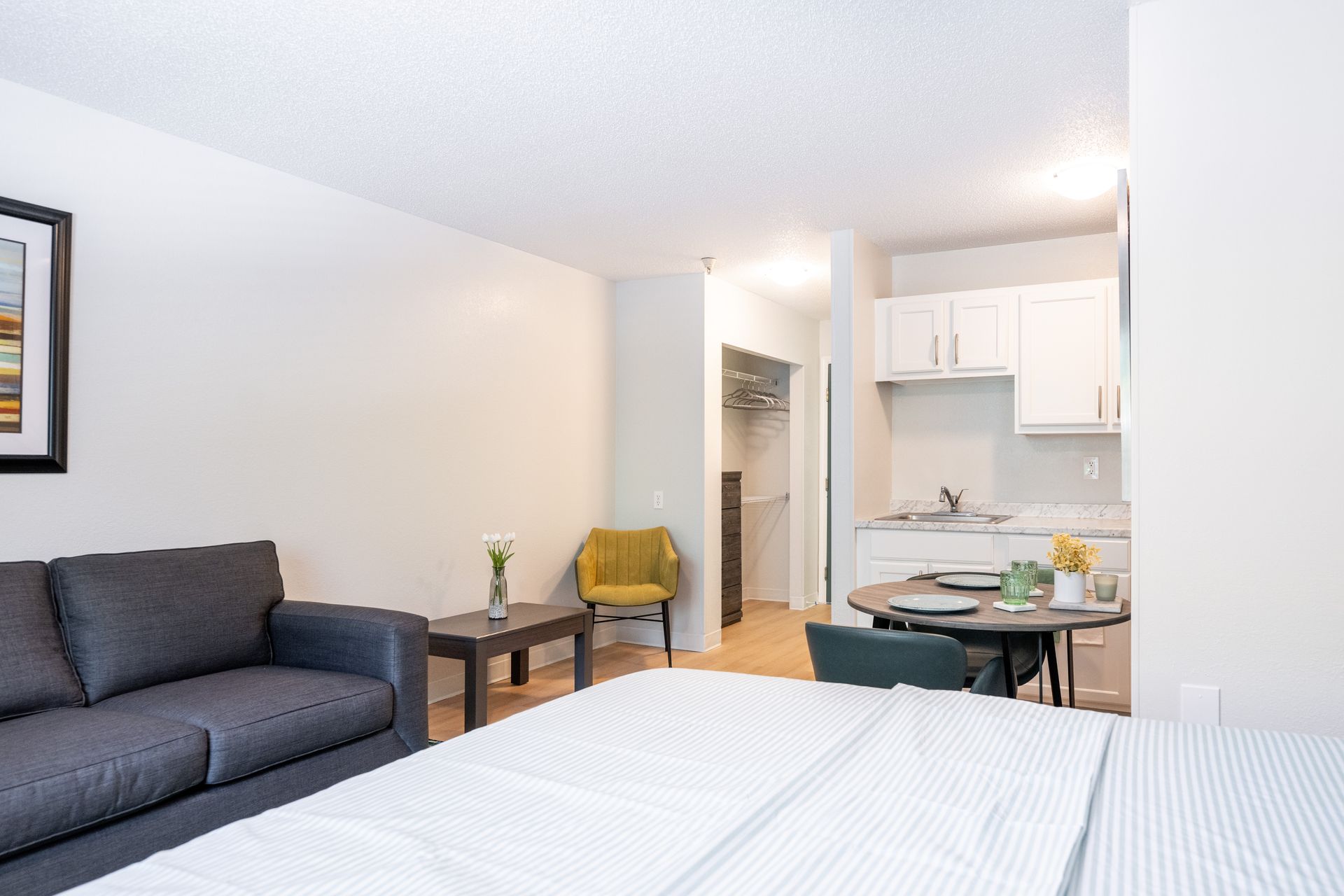A living room with a bed , couch , table and chairs.