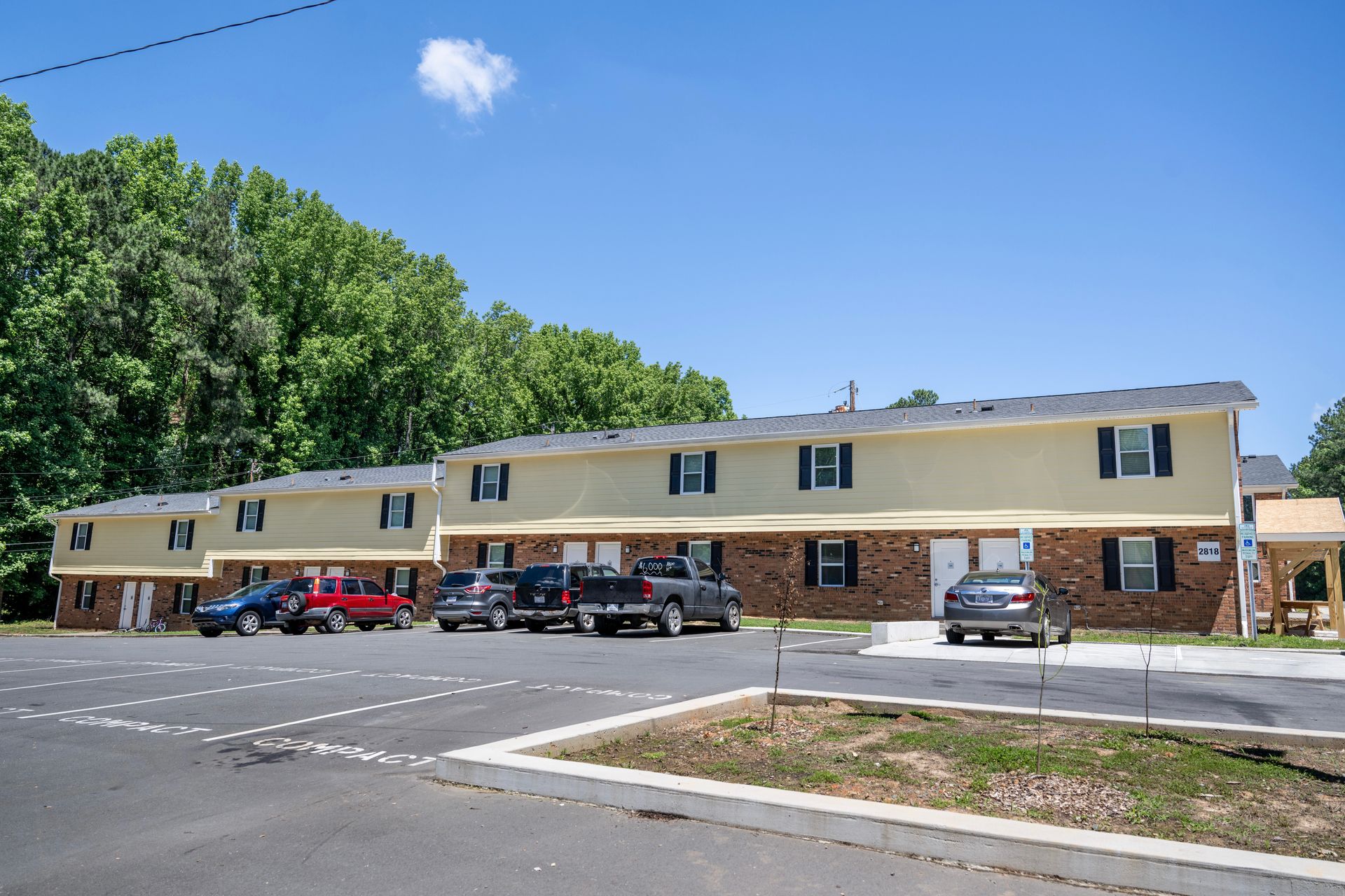 A row of cars are parked in front of a building