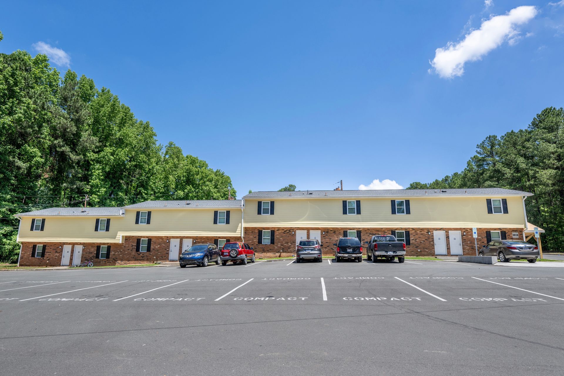 A row of cars are parked in front of a building