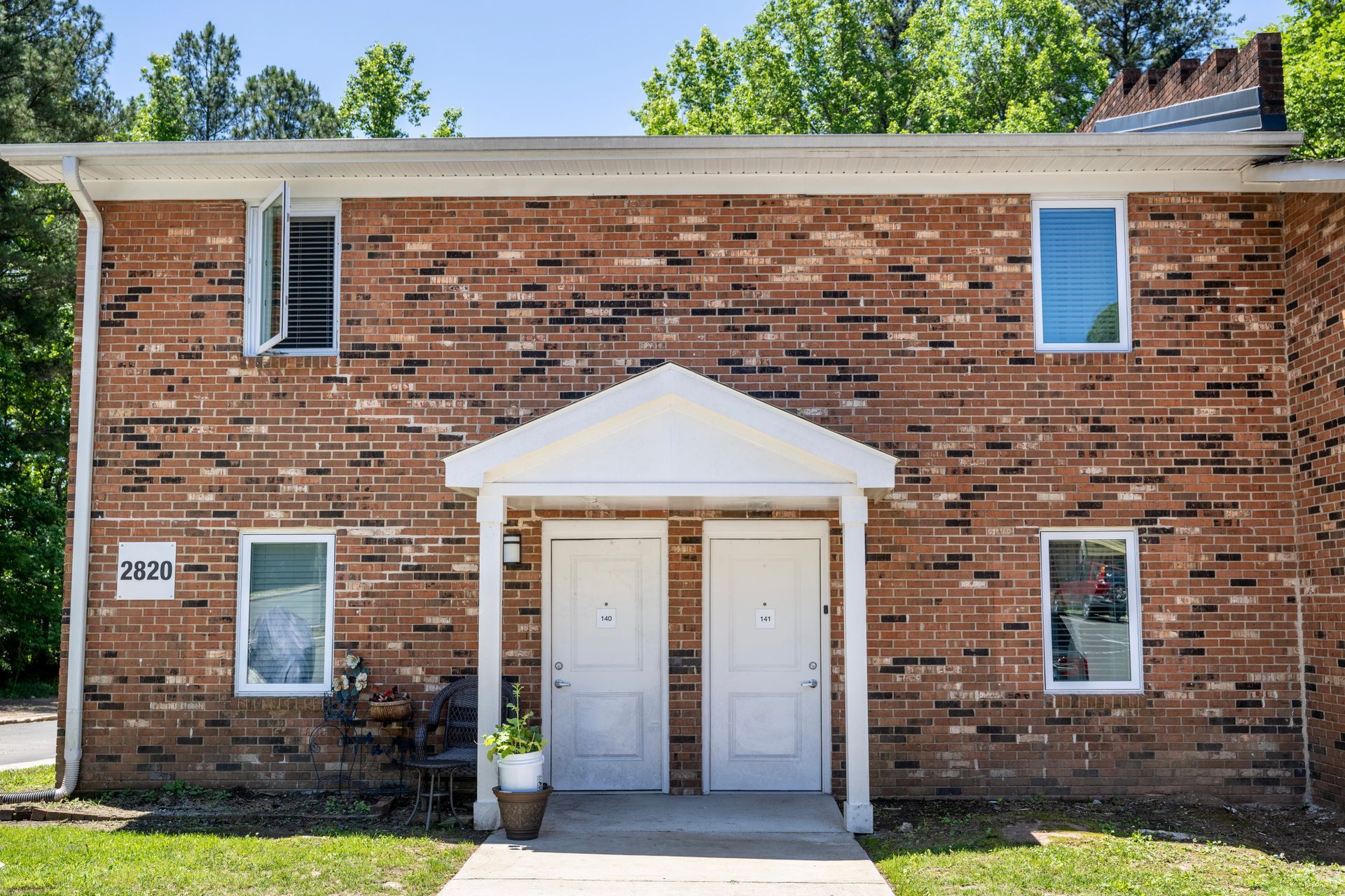 A brick apartment building with white doors and windows