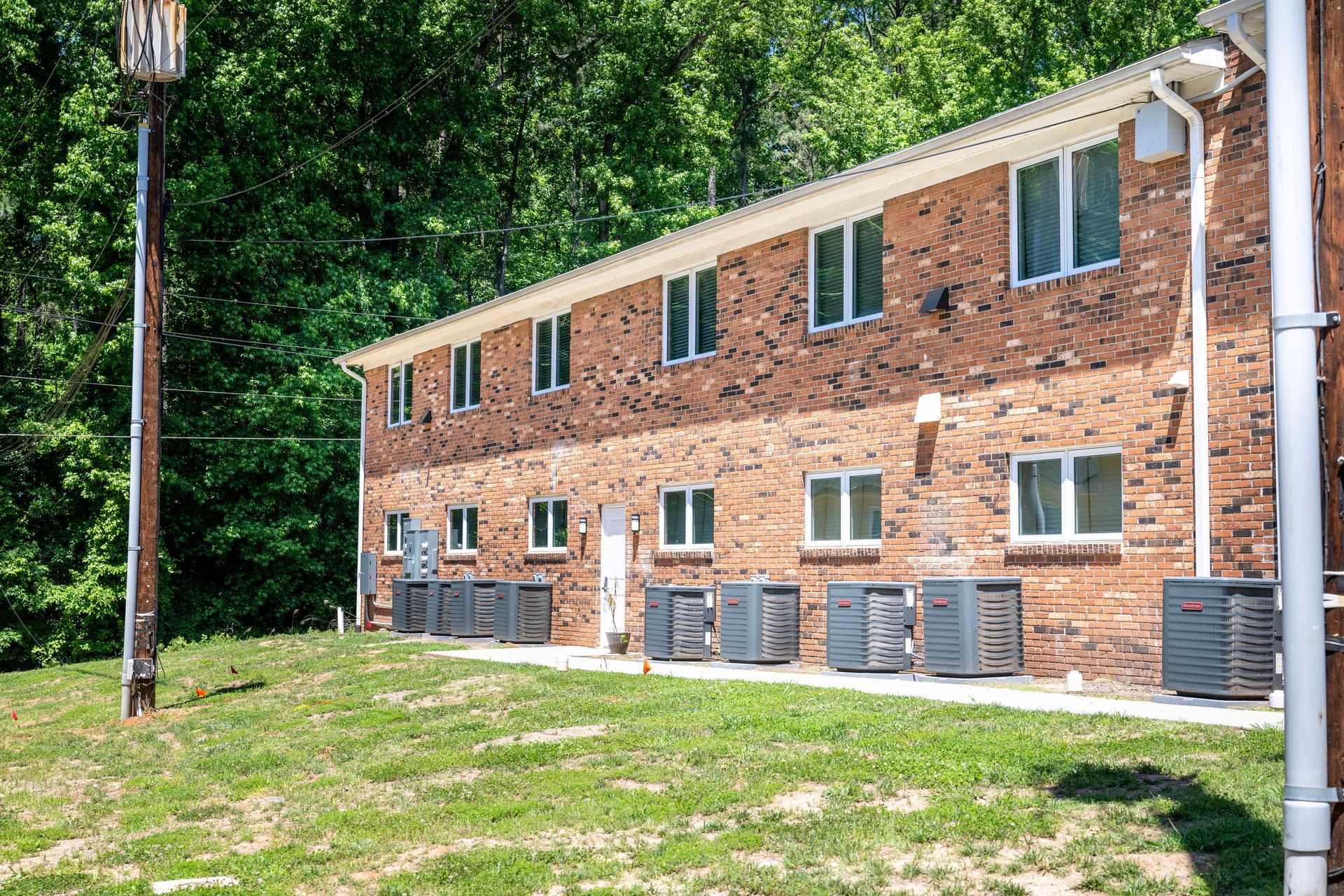 A brick apartment building with a lot of windows and air conditioners.
