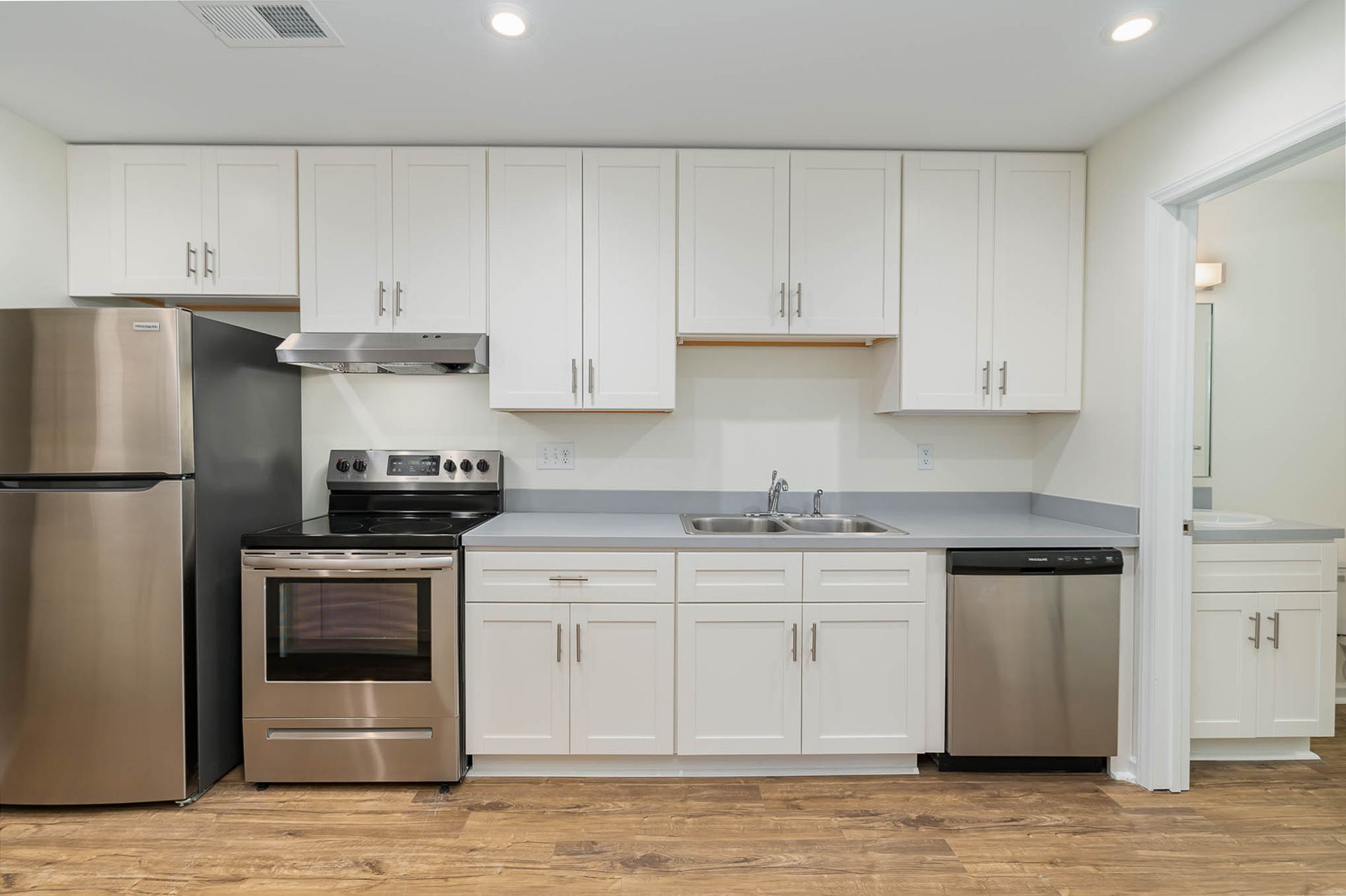 A kitchen with white cabinets and stainless steel appliances.