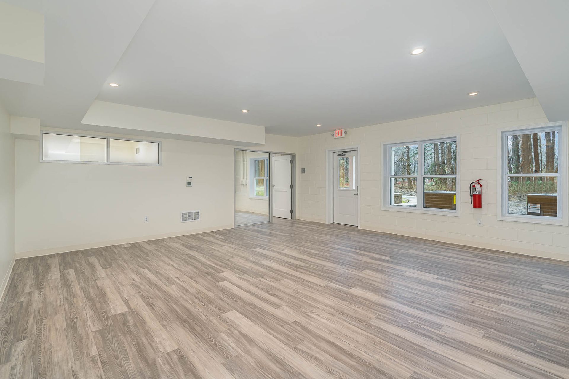 A large empty room with hardwood floors and white walls.