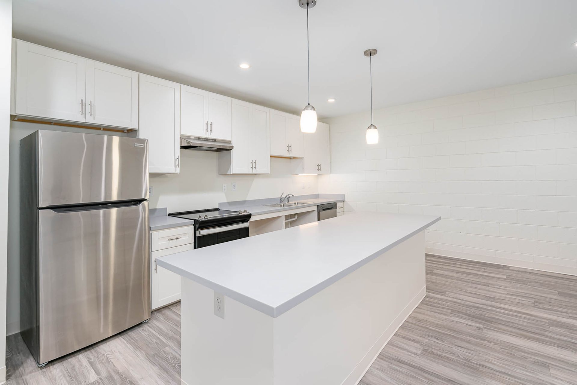 A kitchen with stainless steel appliances and white cabinets.