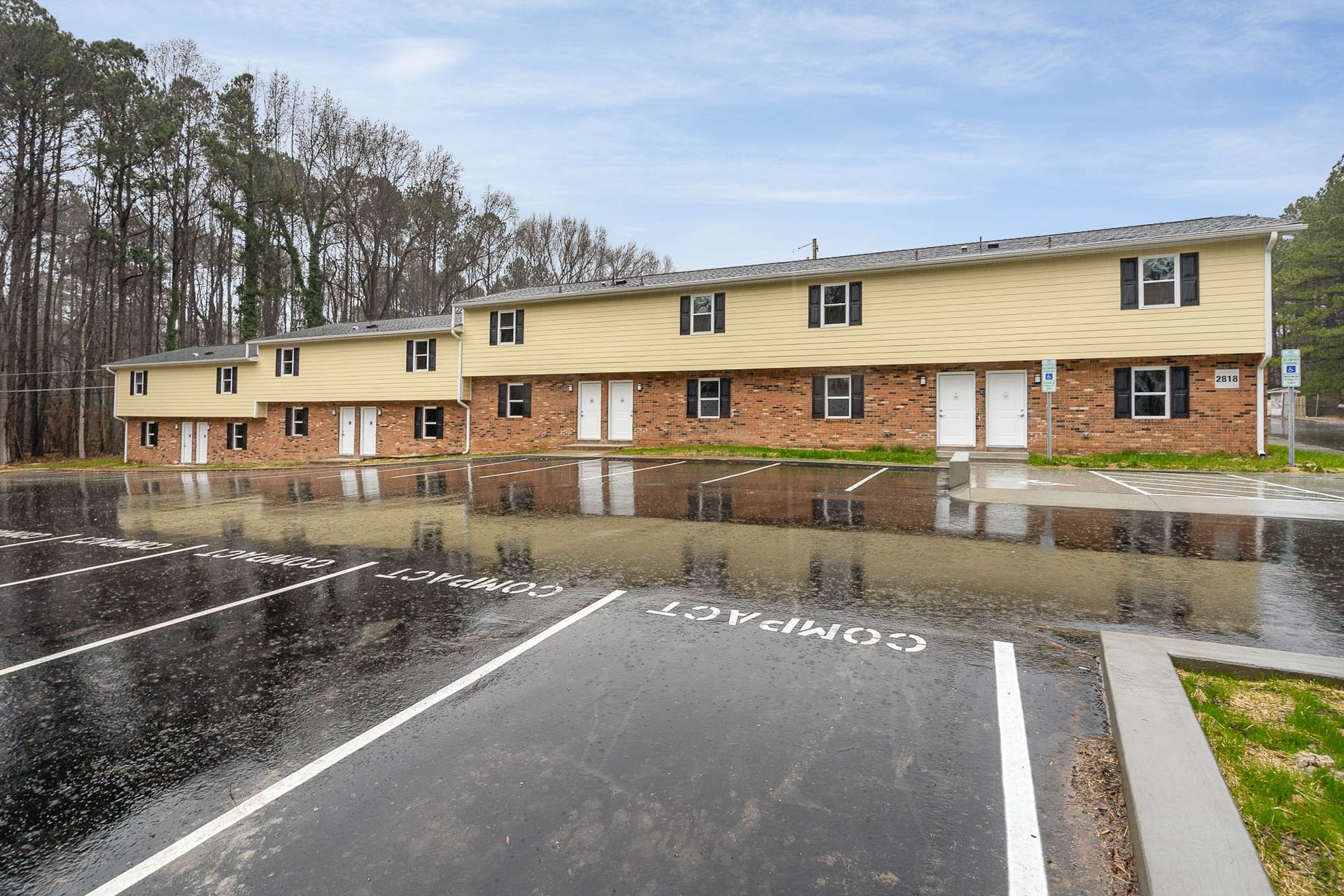 A row of apartment buildings with a parking lot in front of them