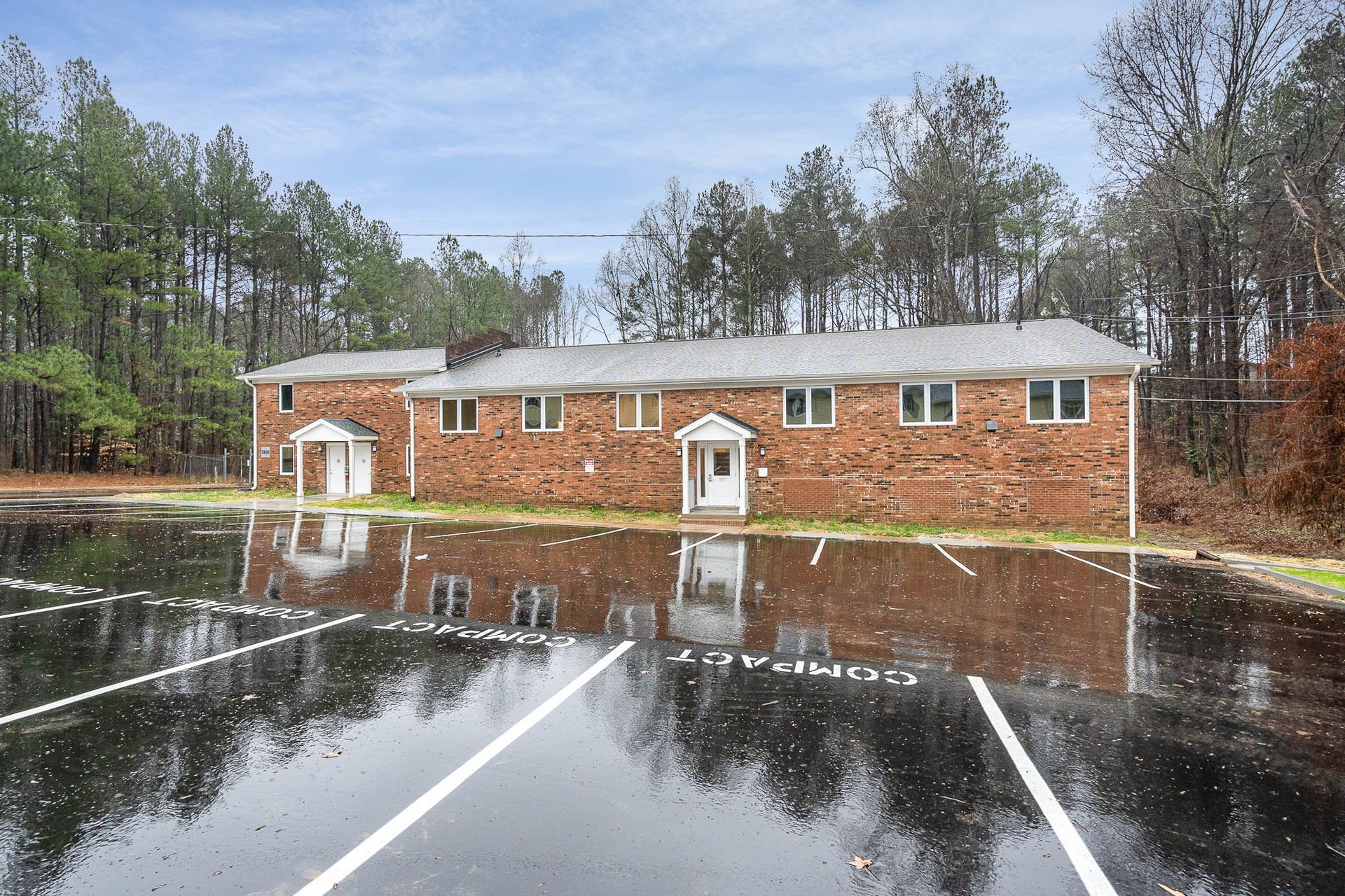A brick building with a parking lot in front of it