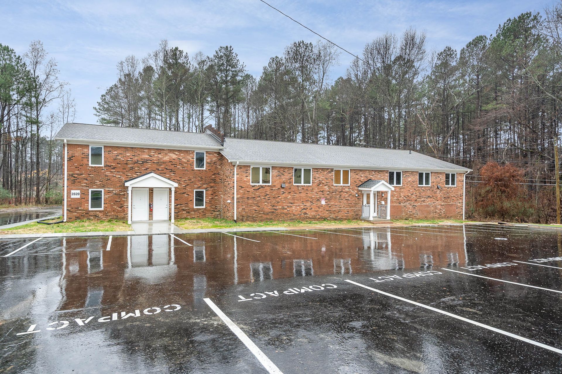 A brick building with a parking lot in front of it