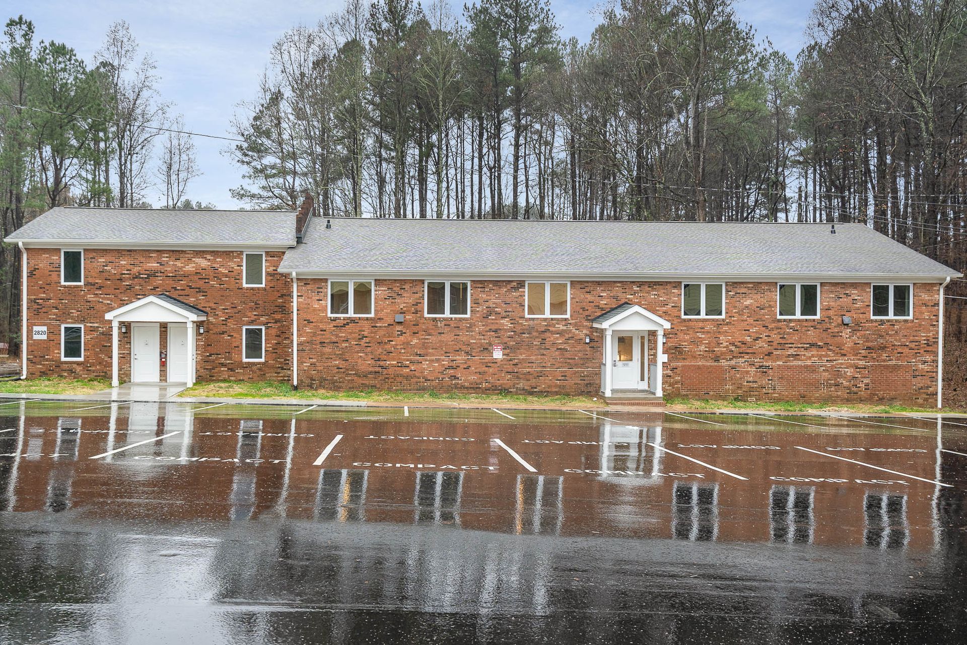 A row of brick houses sit next to each other on a rainy day