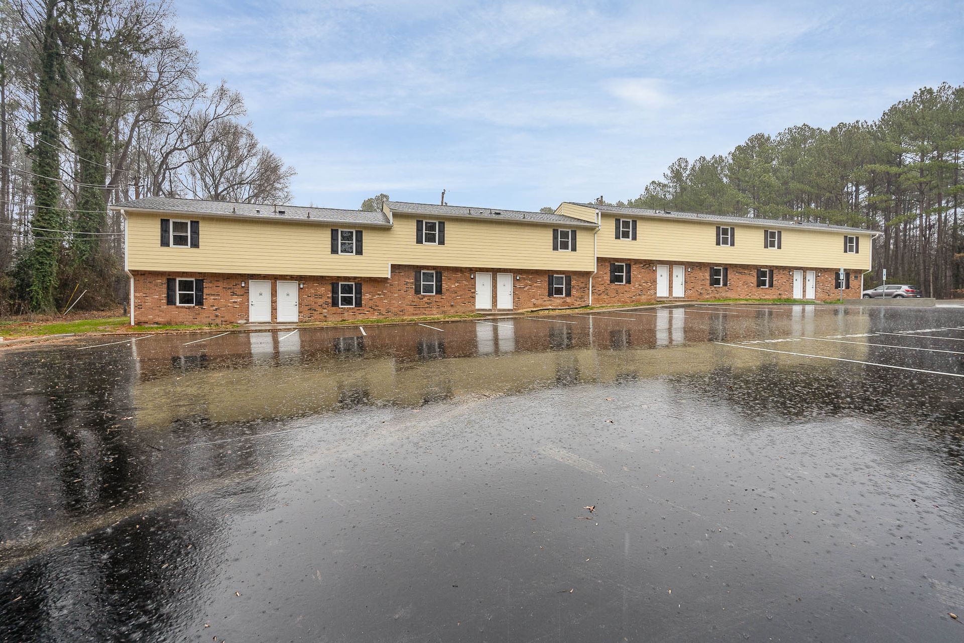 A row of apartment buildings are surrounded by a flooded parking lot