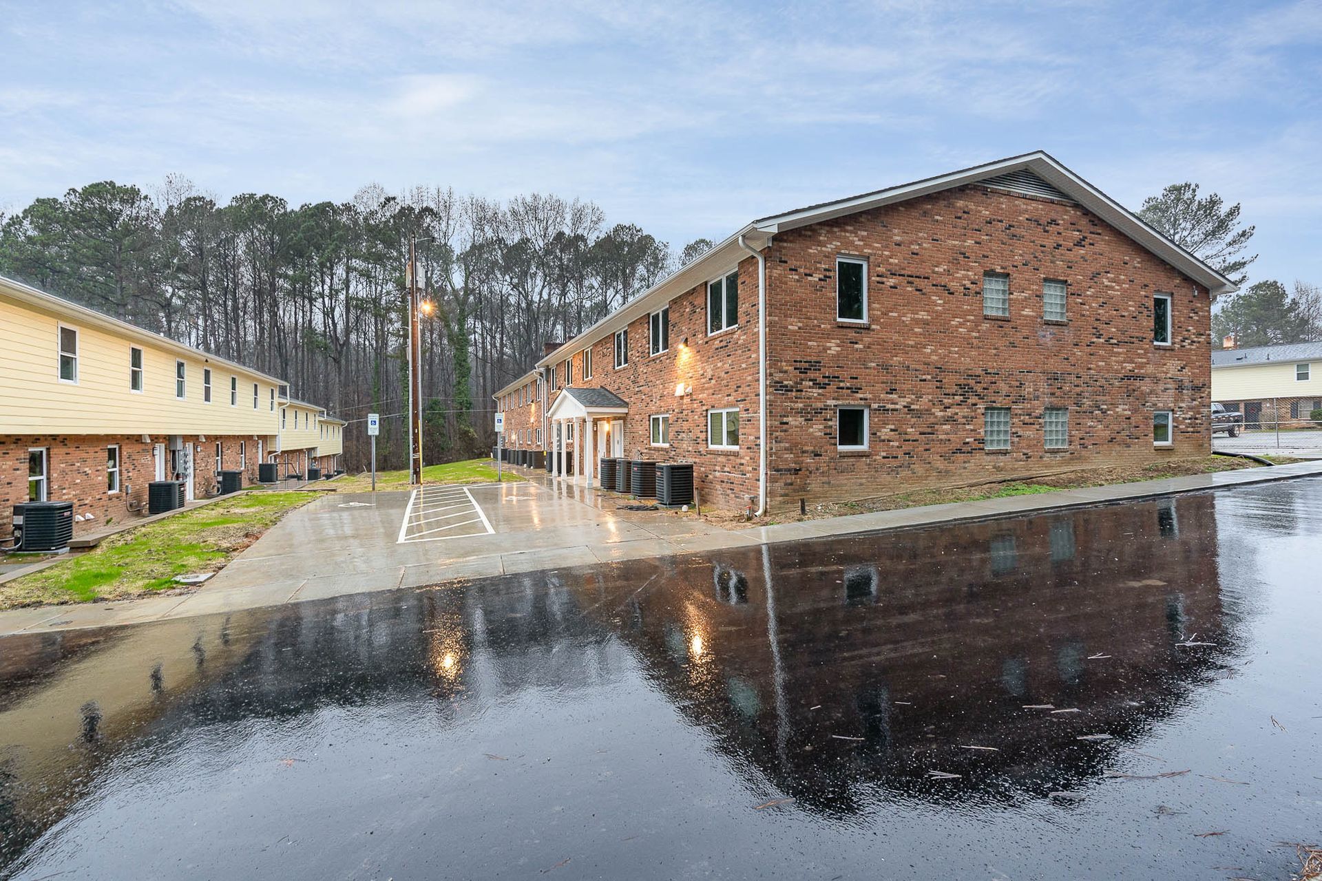 A brick apartment building with a lot of water in front of it.