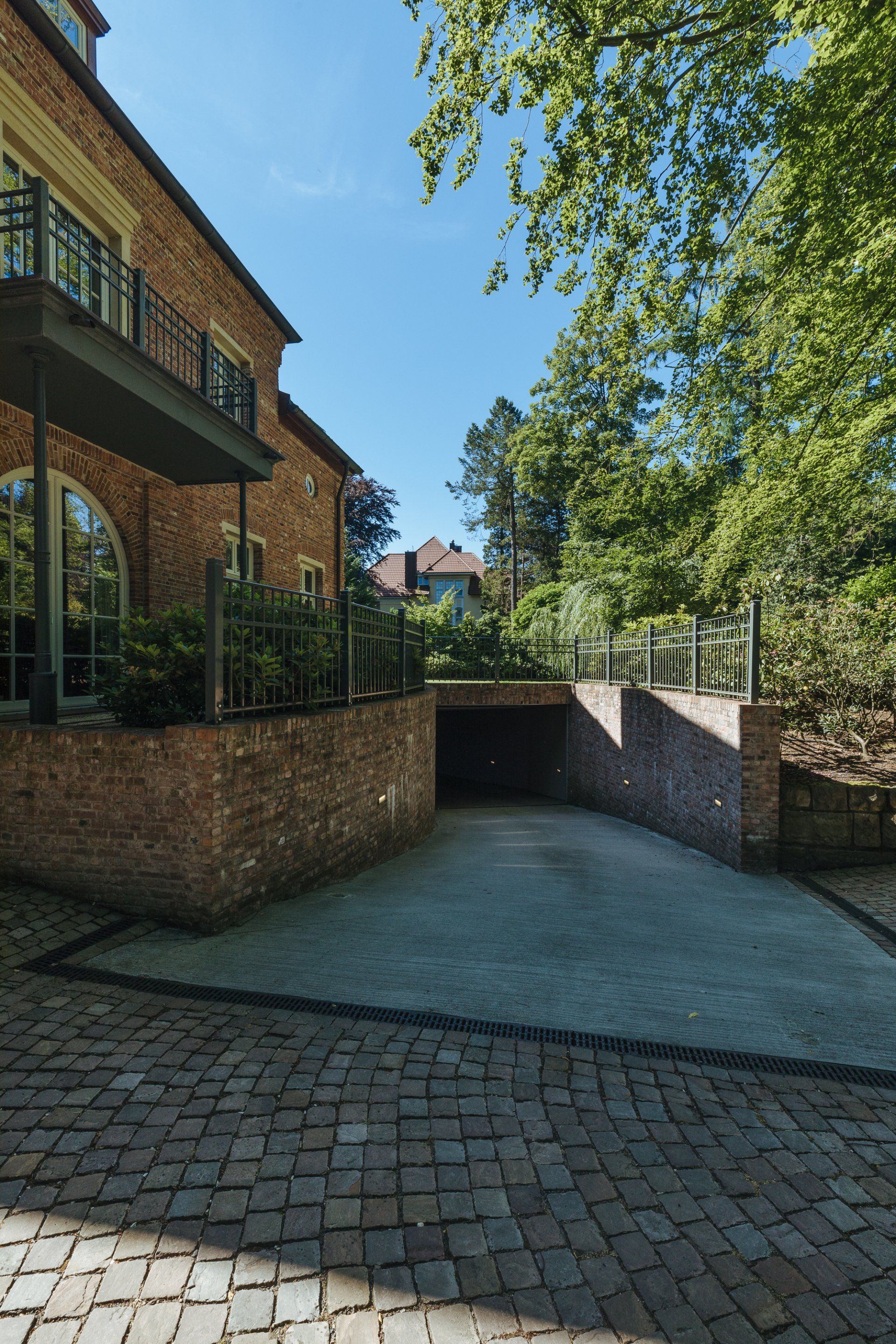 Ein Backsteingebäude mit einer Auffahrt, die zu einer Garage führt.