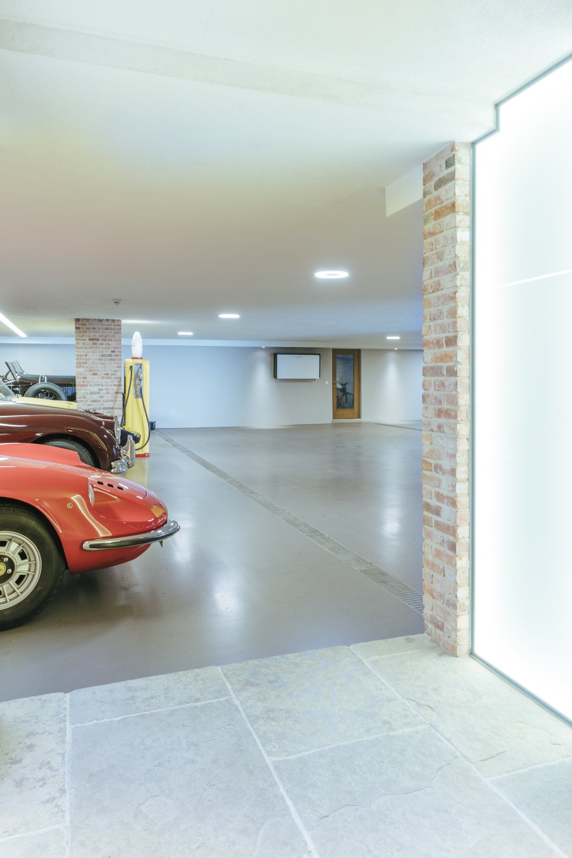 Ein rotes Auto ist mit anderen Autos in einer Garage geparkt.