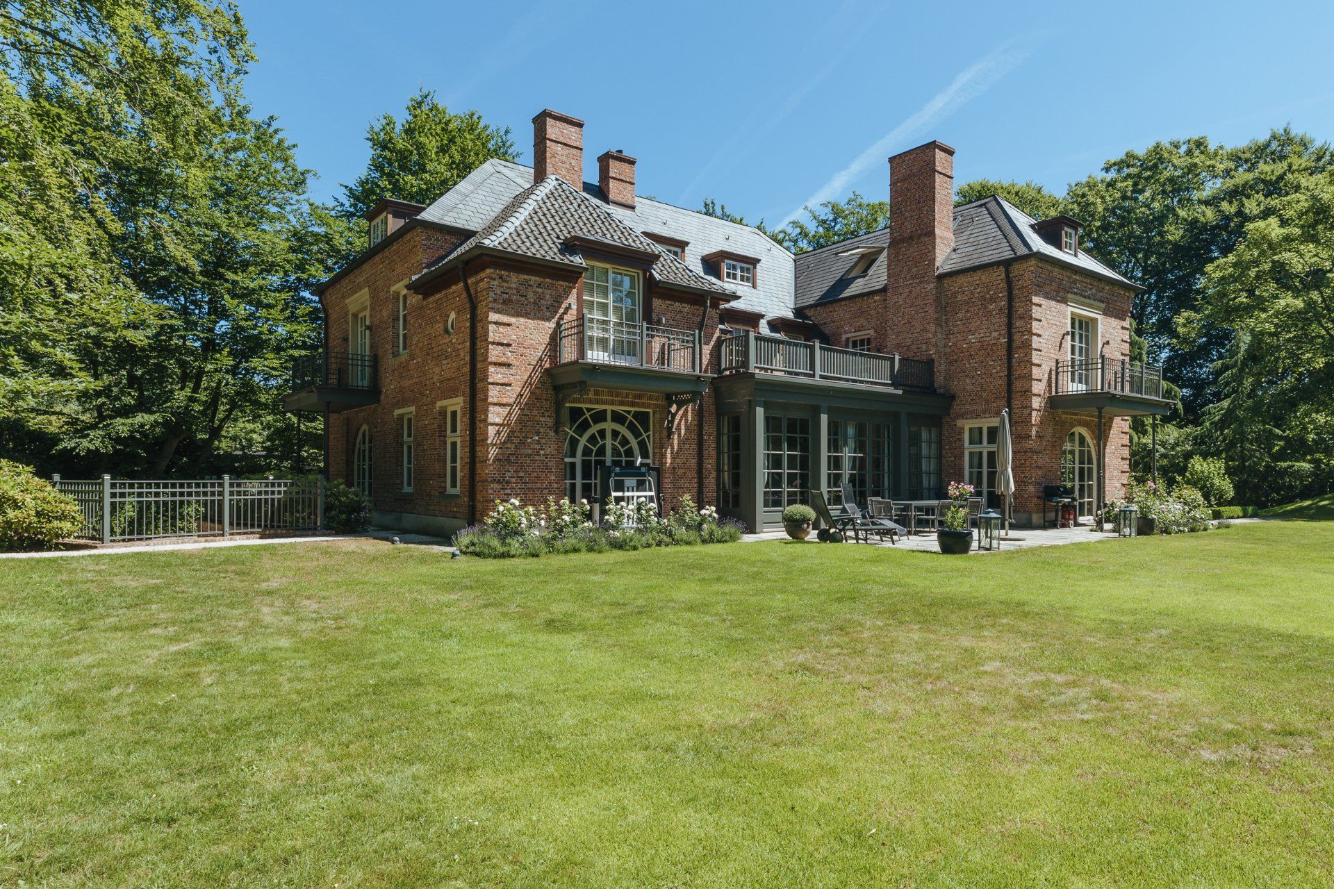 Ein großes Backsteinhaus mit einem großen Rasen davor