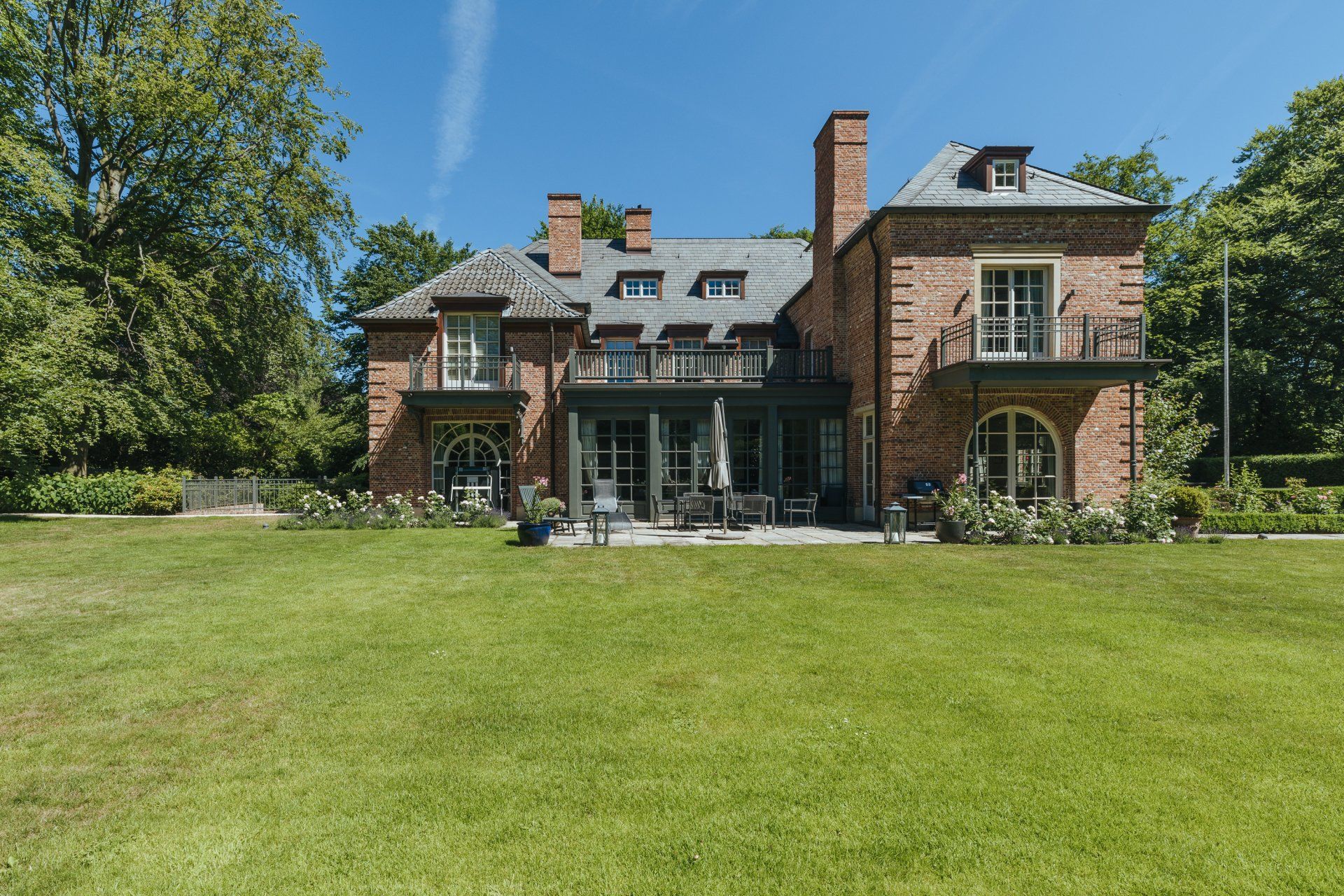 Ein großes Backsteinhaus mit einer großen Wiese davor.