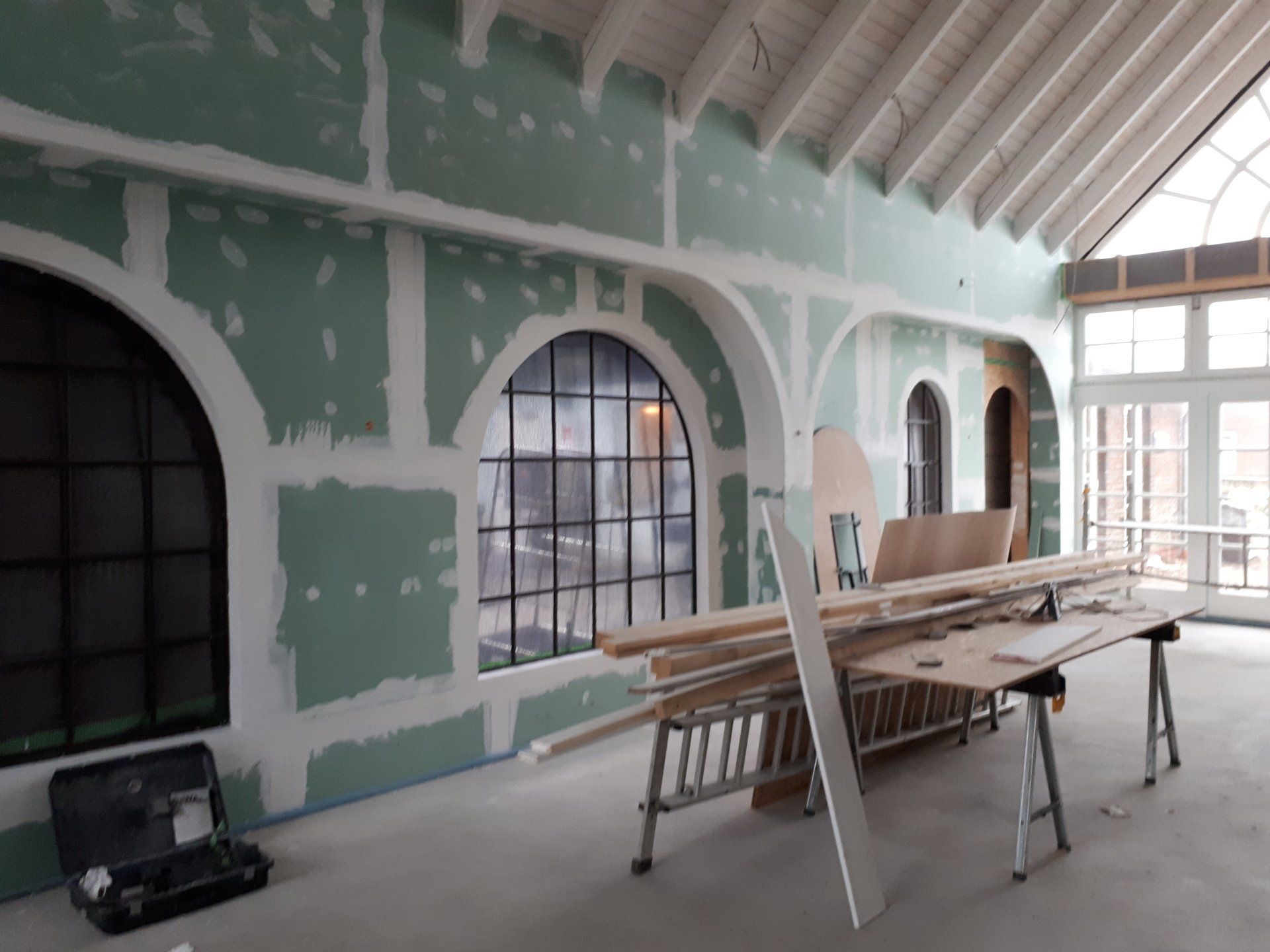 Ein Raum mit vielen Fenstern und einer Leiter