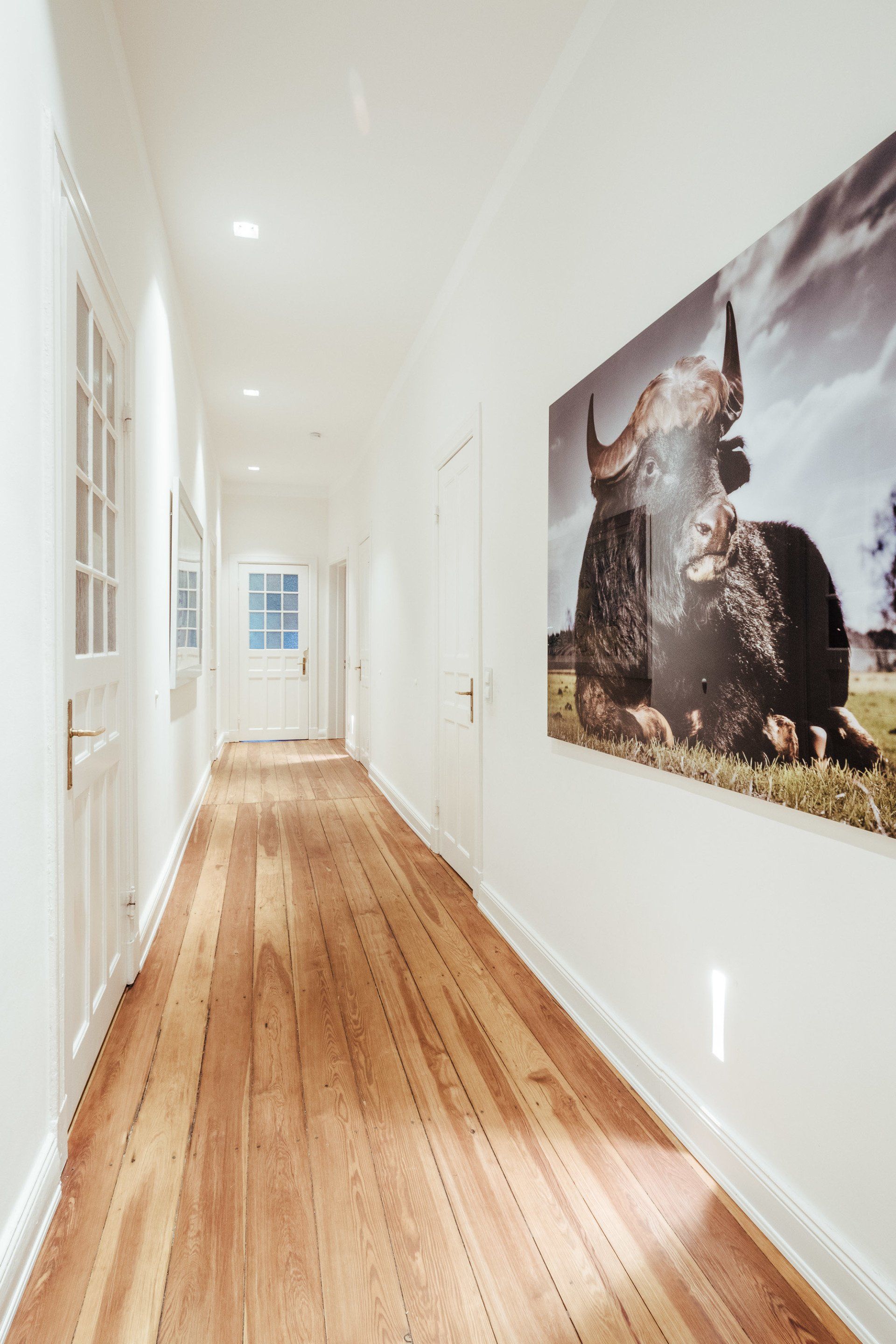 Ein langer Flur mit einem Bild von einem Stier an der Wand