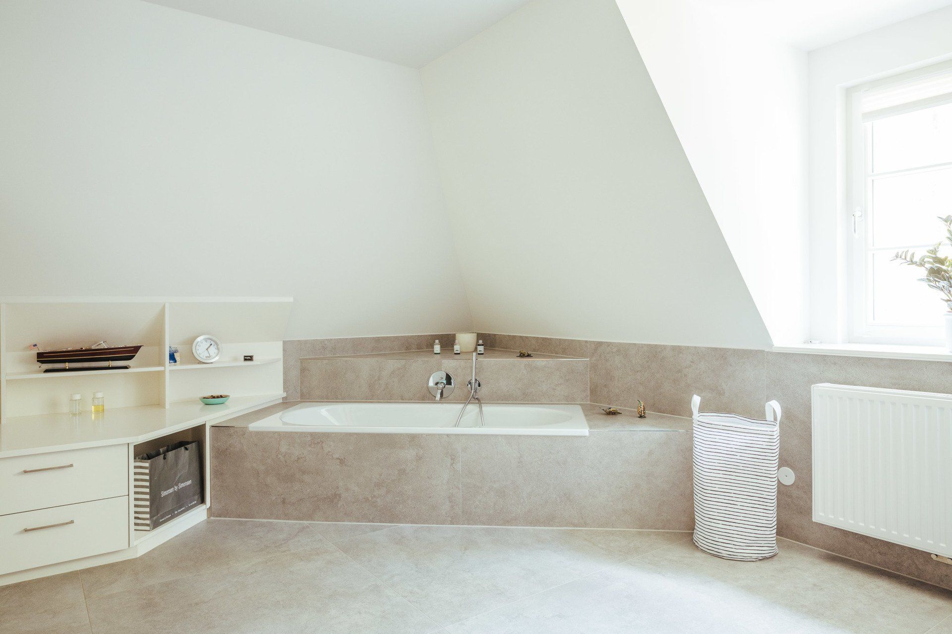 Ein Badezimmer mit Badewanne und Wäschekorb