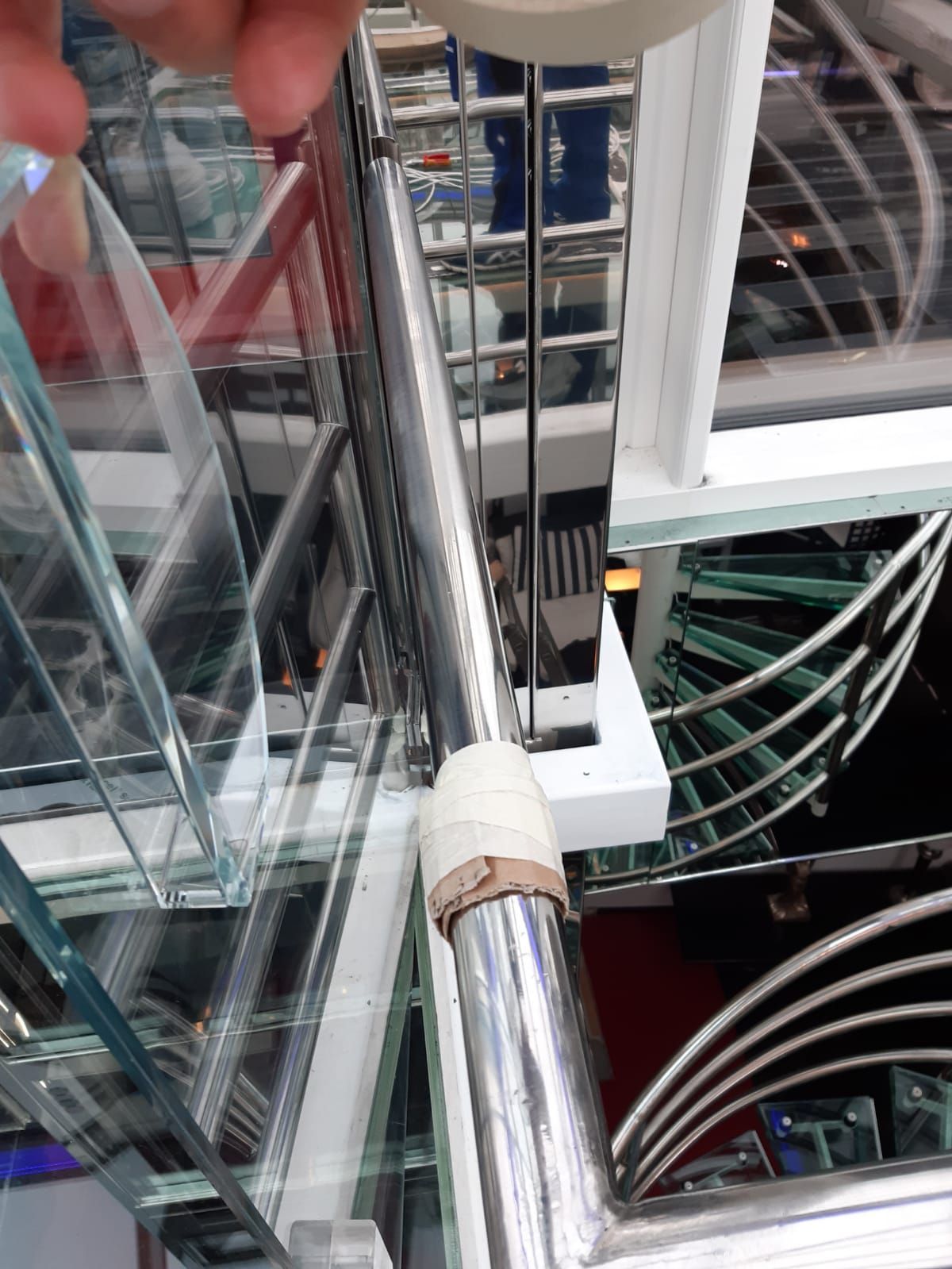 Eine Person schaut in einem Einkaufszentrum auf ein Riesenrad hinunter.