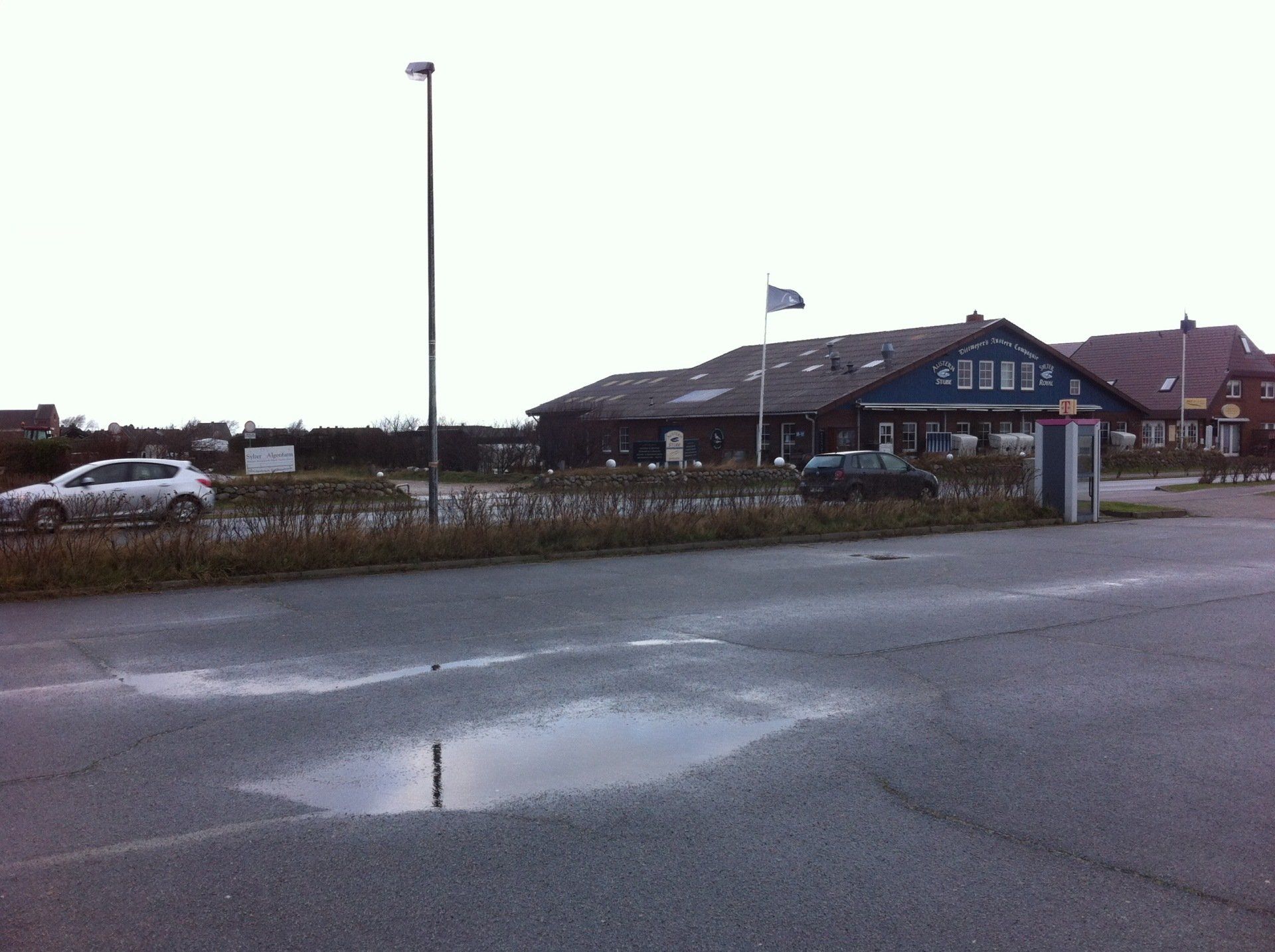 Ein weißes Auto steht auf einem Parkplatz vor einem Gebäude
